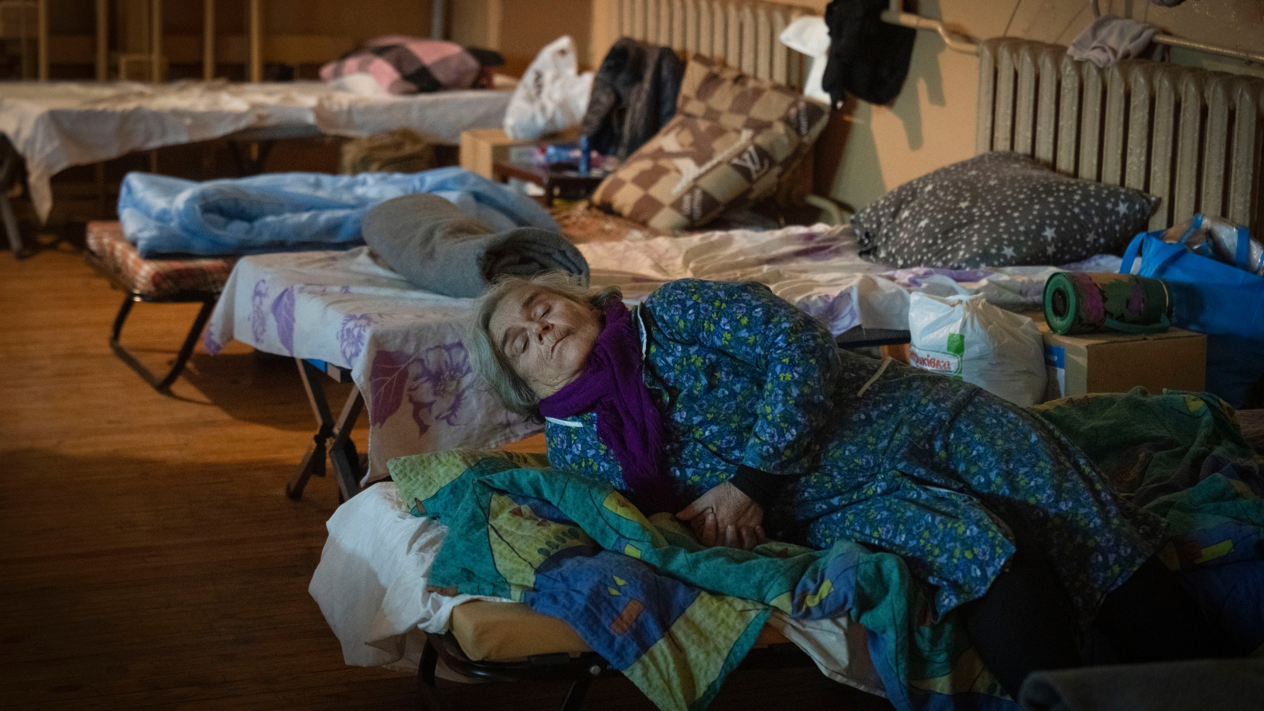 A refugee from Pokrovsk sits on a bed in a city theatre that hosts refugees running from Russian offensive in the Donetsk region, in Pavlohrad, Dnipropetrovsk region, Ukraine, Thursday, Dec. 12, 2024.(AP Photo/Efrem Lukatsky)