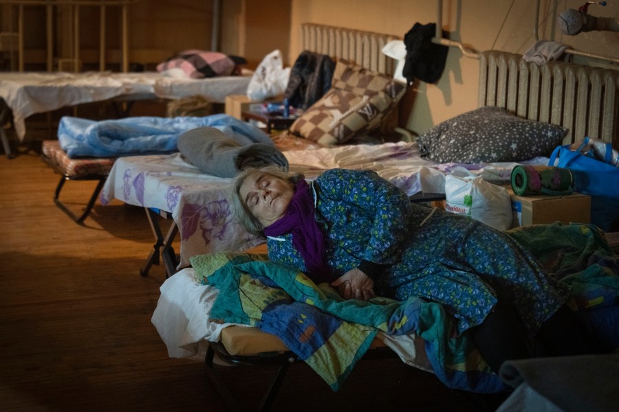 A refugee from Pokrovsk sits on a bed in a city theatre that hosts refugees running from Russian offensive in the Donetsk region, in Pavlohrad, Dnipropetrovsk region, Ukraine, Thursday, Dec. 12, 2024.(AP Photo/Efrem Lukatsky)