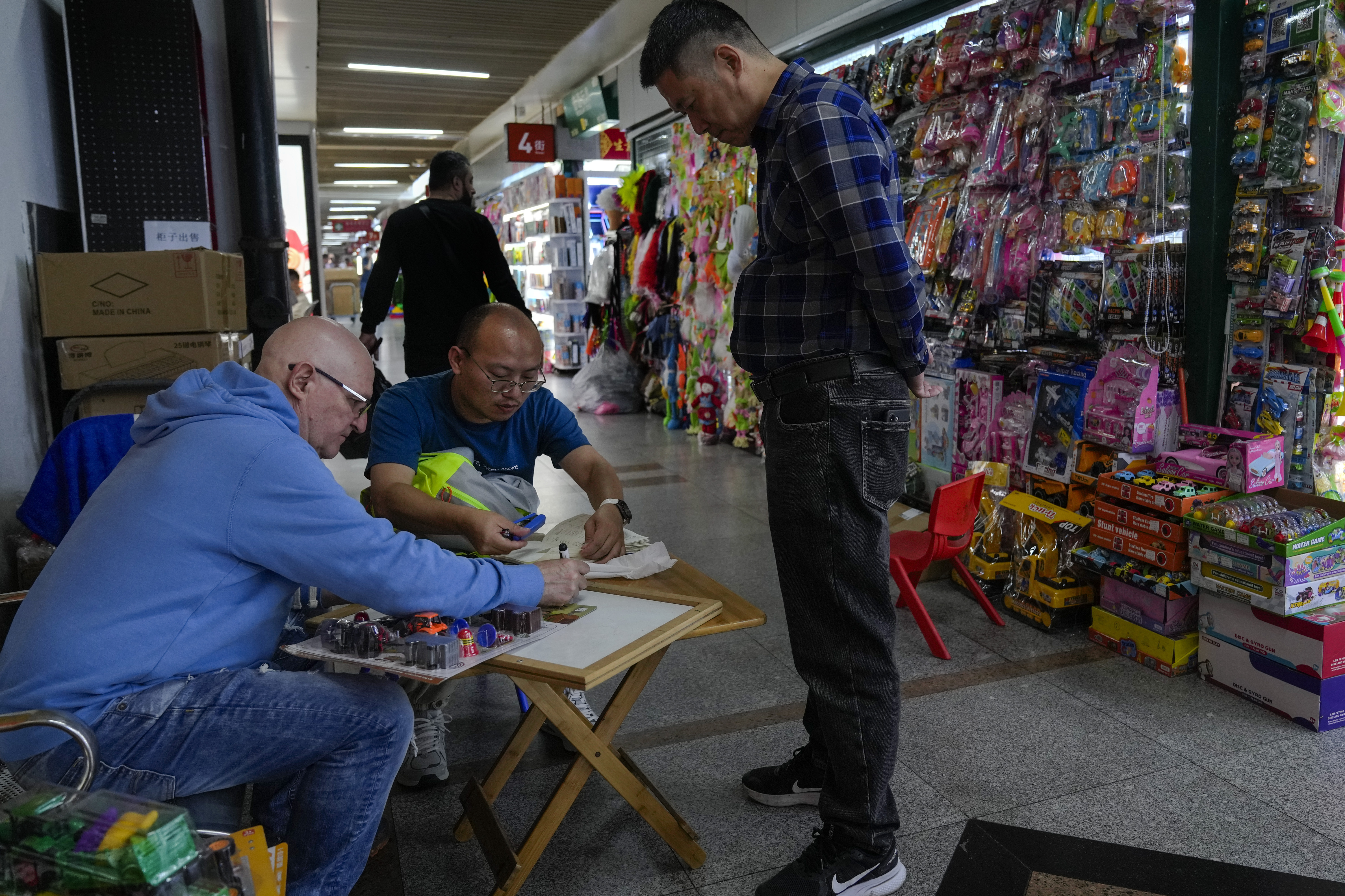 FILE - A foreign buyer bargains toys prices with a vendor at the Yiwu wholesale market in Yiwu, east China's Zhejiang province on Nov. 8, 2024. (AP Photo/Andy Wong, File)