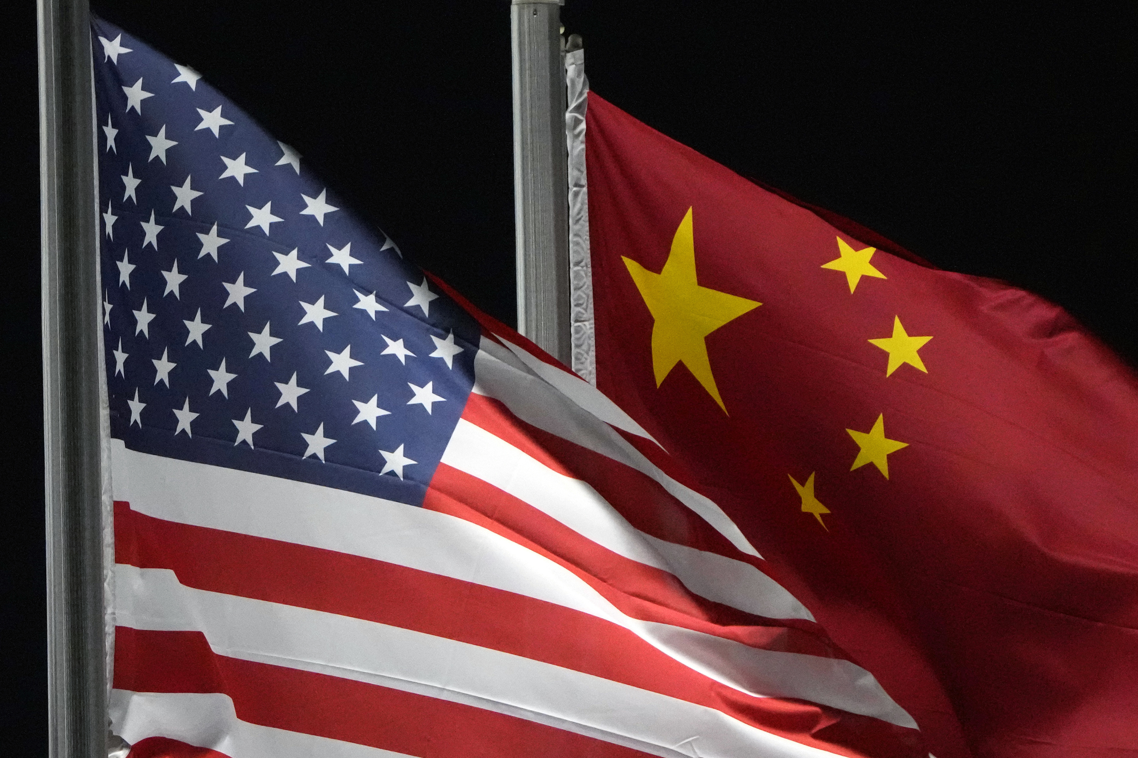 FILE - The American and Chinese flags wave at Genting Snow Park ahead of the 2022 Winter Olympics, in Zhangjiakou, China, Feb. 2, 2022. (AP Photo/Kiichiro Sato, File)