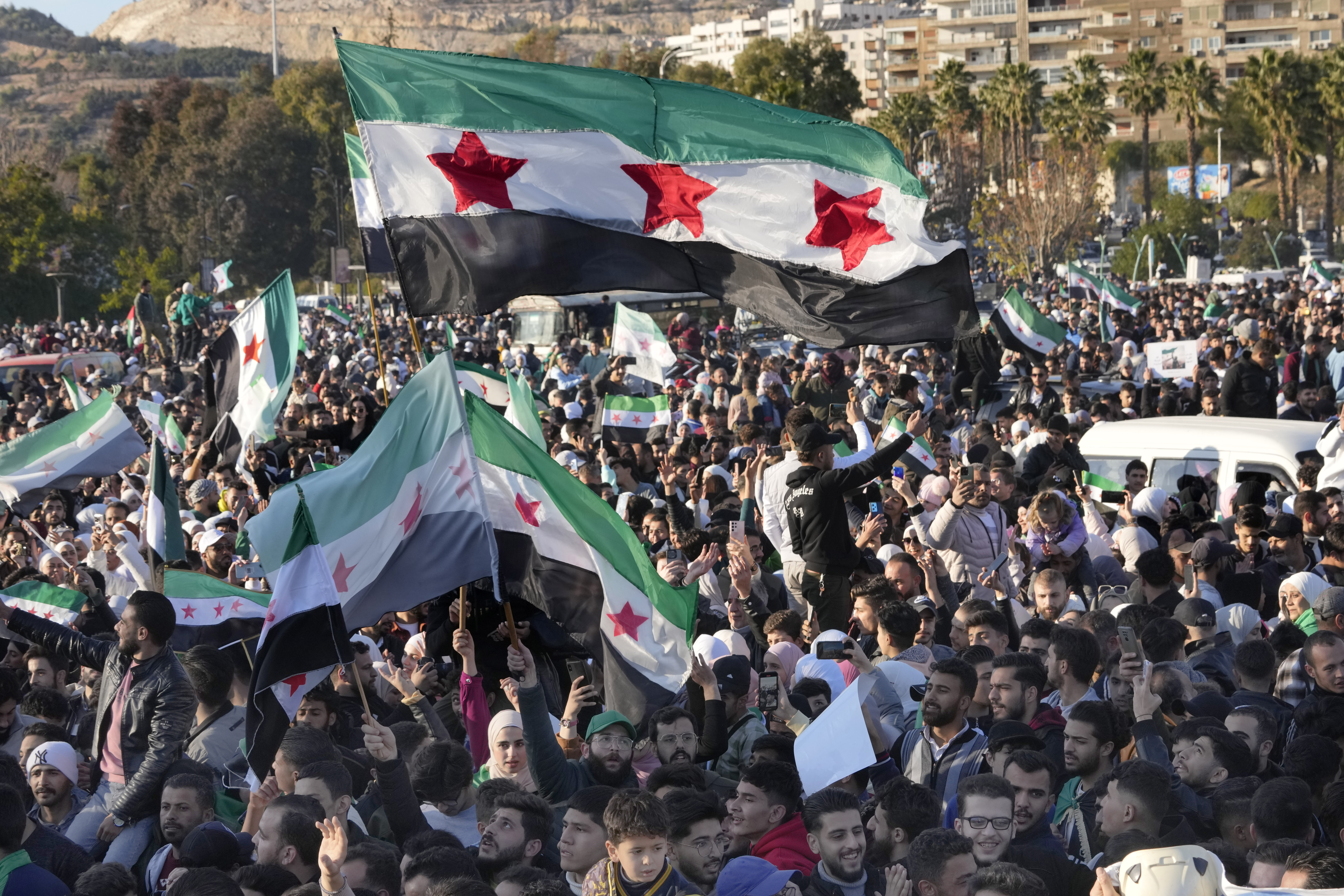 Syrians celebrate during a demonstration following the first Friday prayers since Bashar Assad's ouster, in Damascus' central square, Syria, on Friday, Dec. 13, 2024. (AP Photo/Hussein Malla)