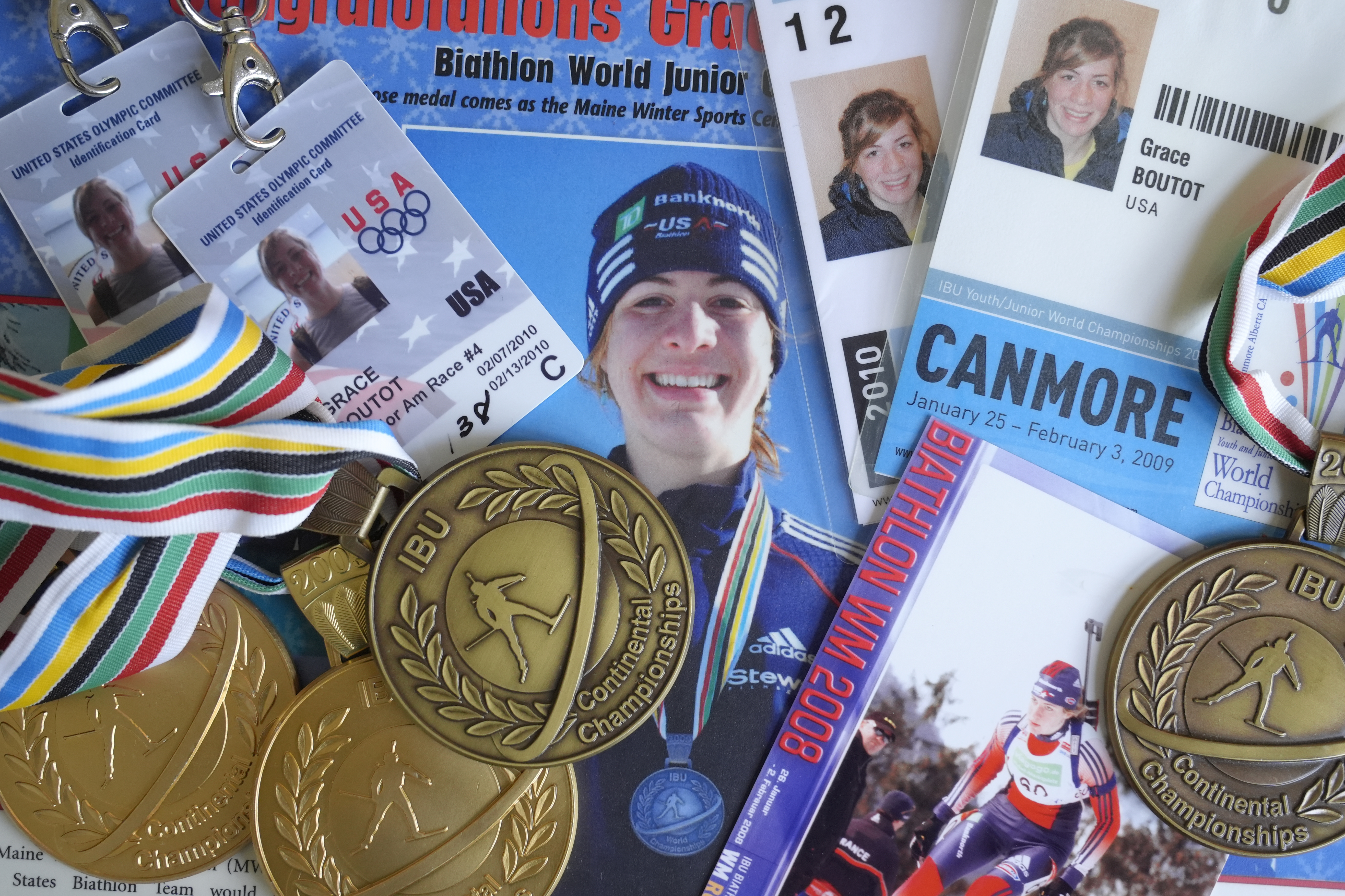 Biathlon competition medals, credentials, and media clippings belonging to Grace Boutot, silver medalist in Youth World Championships in 2009, are displayed for a photograph at her home, Oct. 17, 2024, in Boston. (AP Photo/Steven Senne)