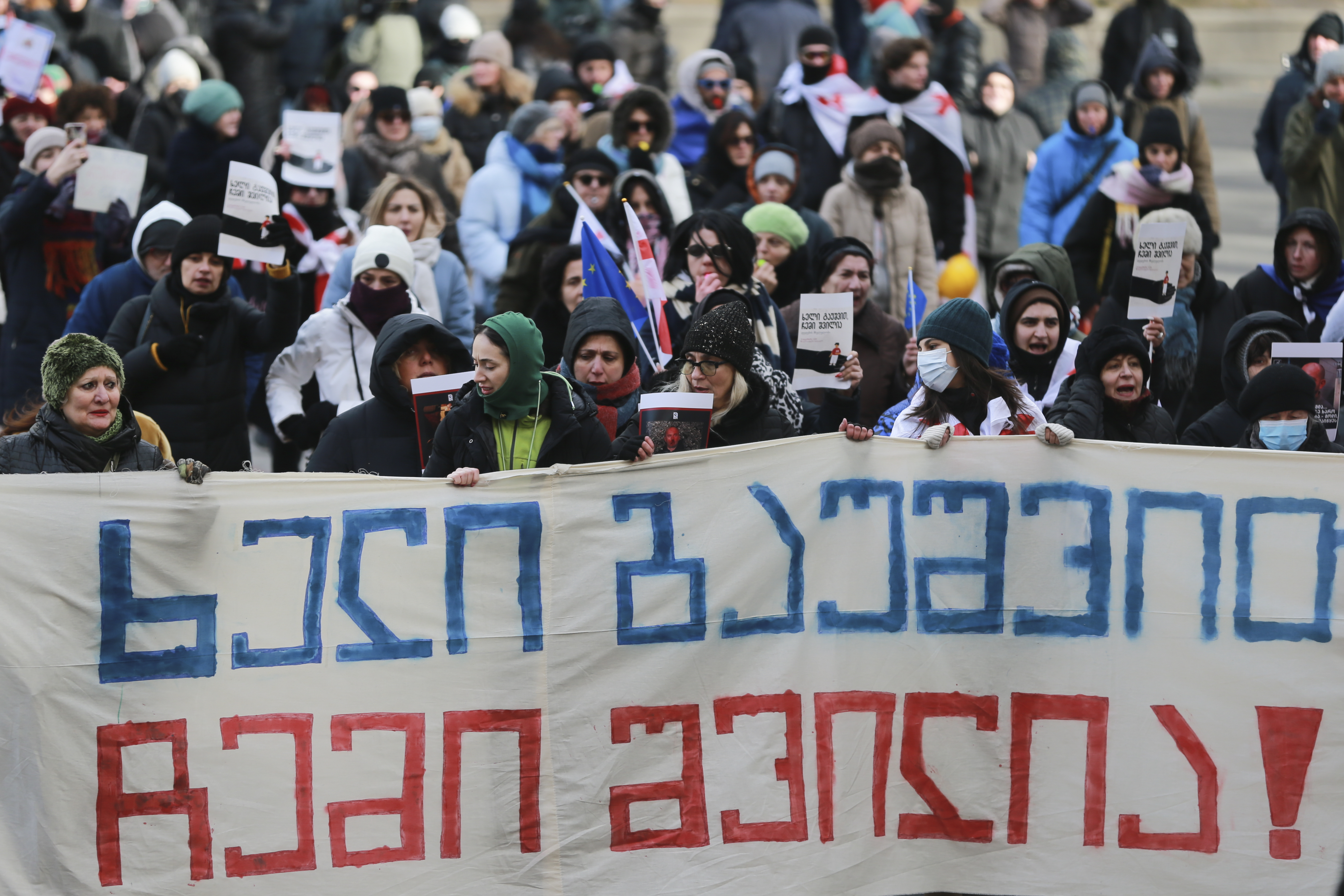 People hold a banner saying "Hands off my child" in Georgian,protesting outside of the Georgian parliament as the parliament begins the procedure of the presidential elections, in Tbilisi, Georgia, Saturday, Dec. 14, 2024. (AP Photo/Zurab Tsertsvadze)