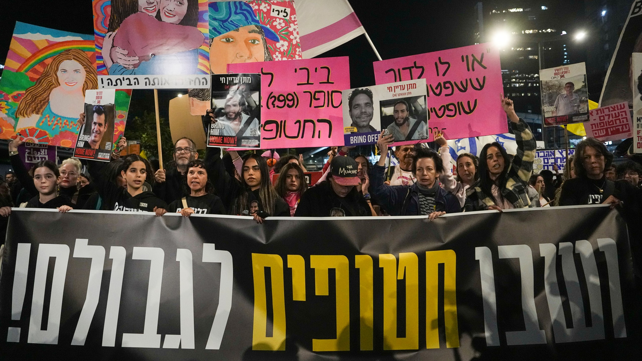 Israelis protest against Prime Minister Benjamin Netanyahu's government and call for the release of hostages held in the Gaza Strip by the Hamas militant group, in Tel Aviv, Israel, Saturday, Dec. 14, 2024. (AP Photo/Tsafrir Abayov)