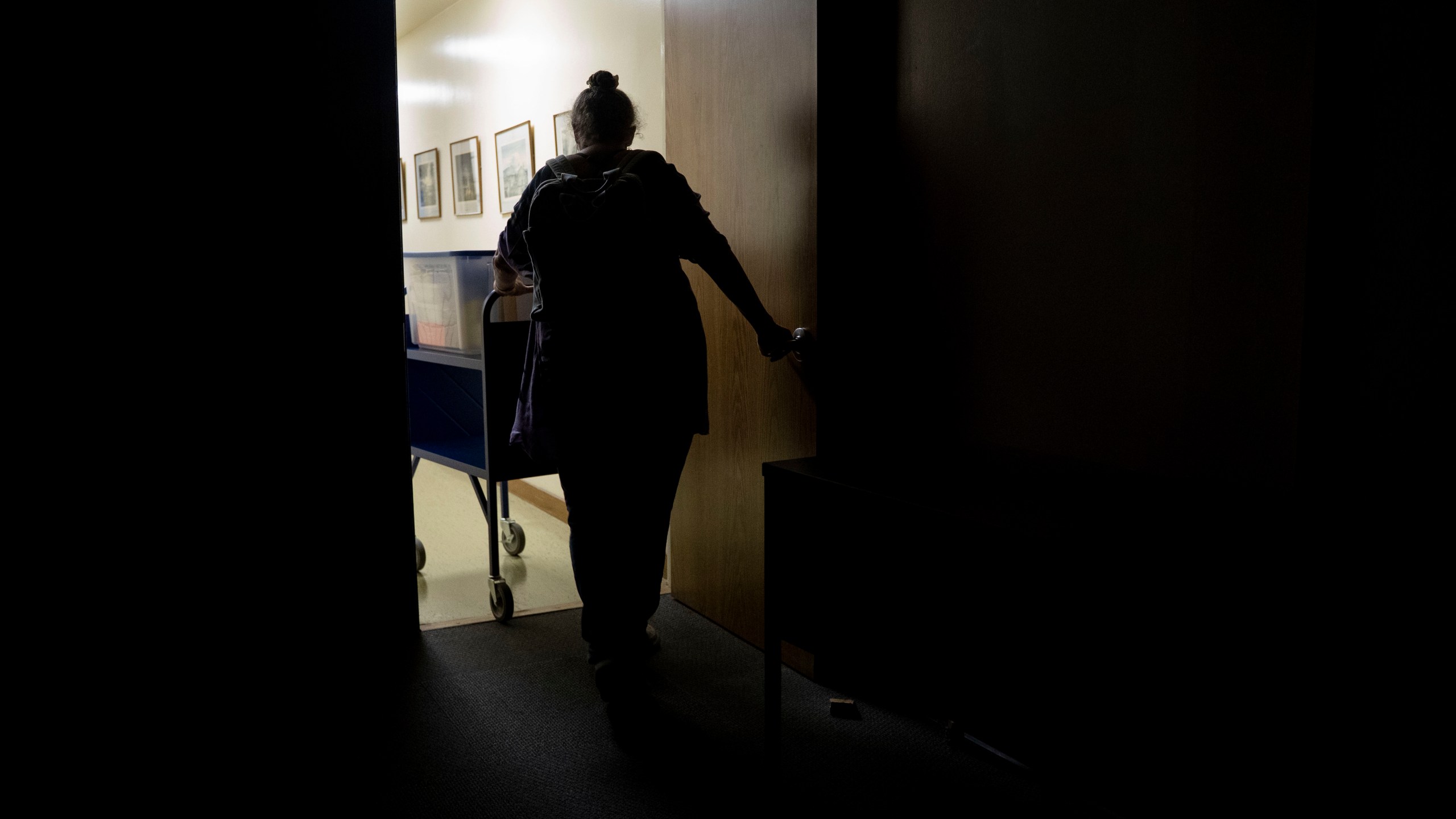 Pam Walton leaves a library with her container including photographs and lists of "Two by Twos" conventions, members and ministers, Monday, Dec. 9, 2024, in Wailea, Hawaii. (AP Photo/Mengshin Lin)