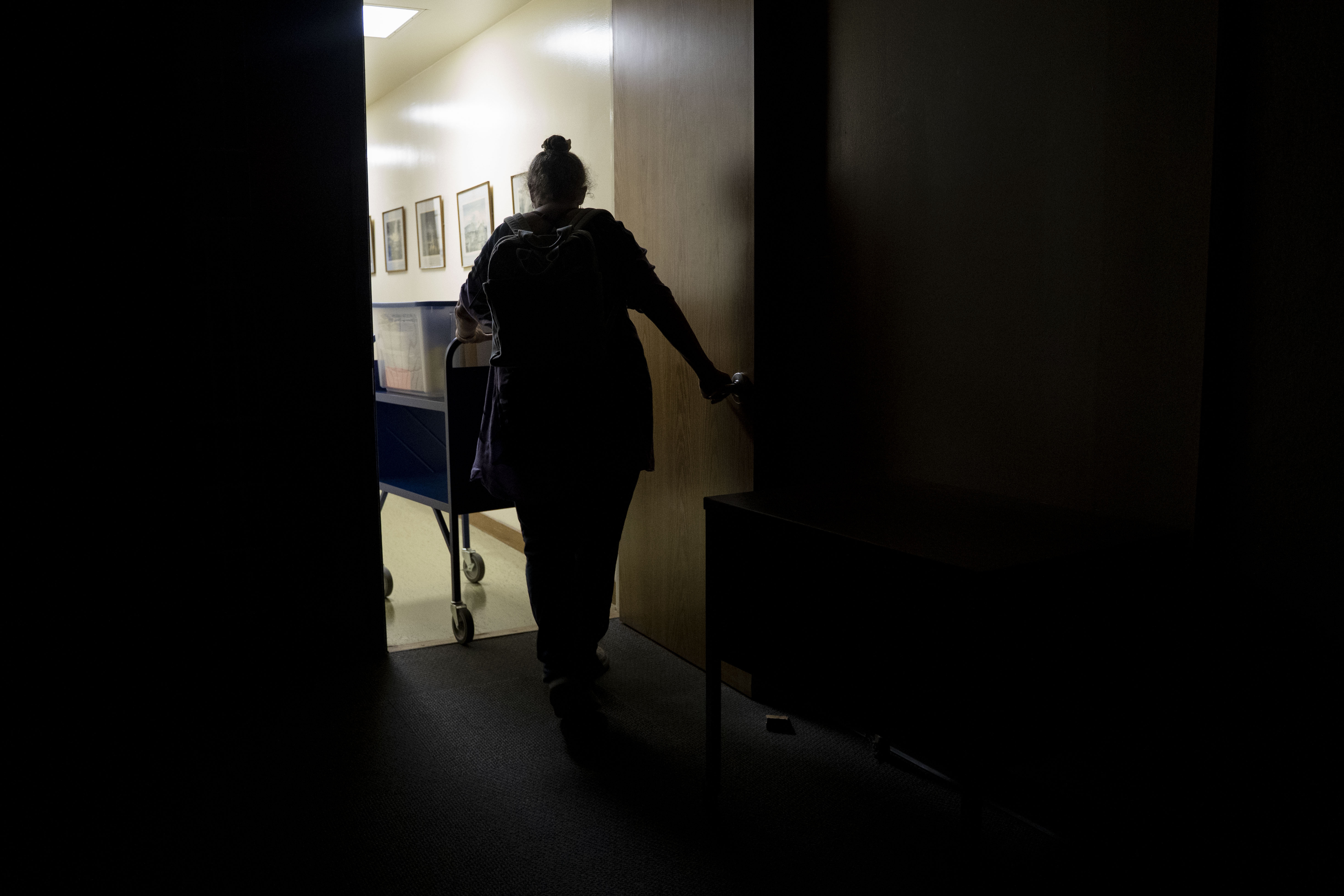 Pam Walton leaves a library with her container including photographs and lists of "Two by Twos" conventions, members and ministers, Monday, Dec. 9, 2024, in Wailea, Hawaii. (AP Photo/Mengshin Lin)