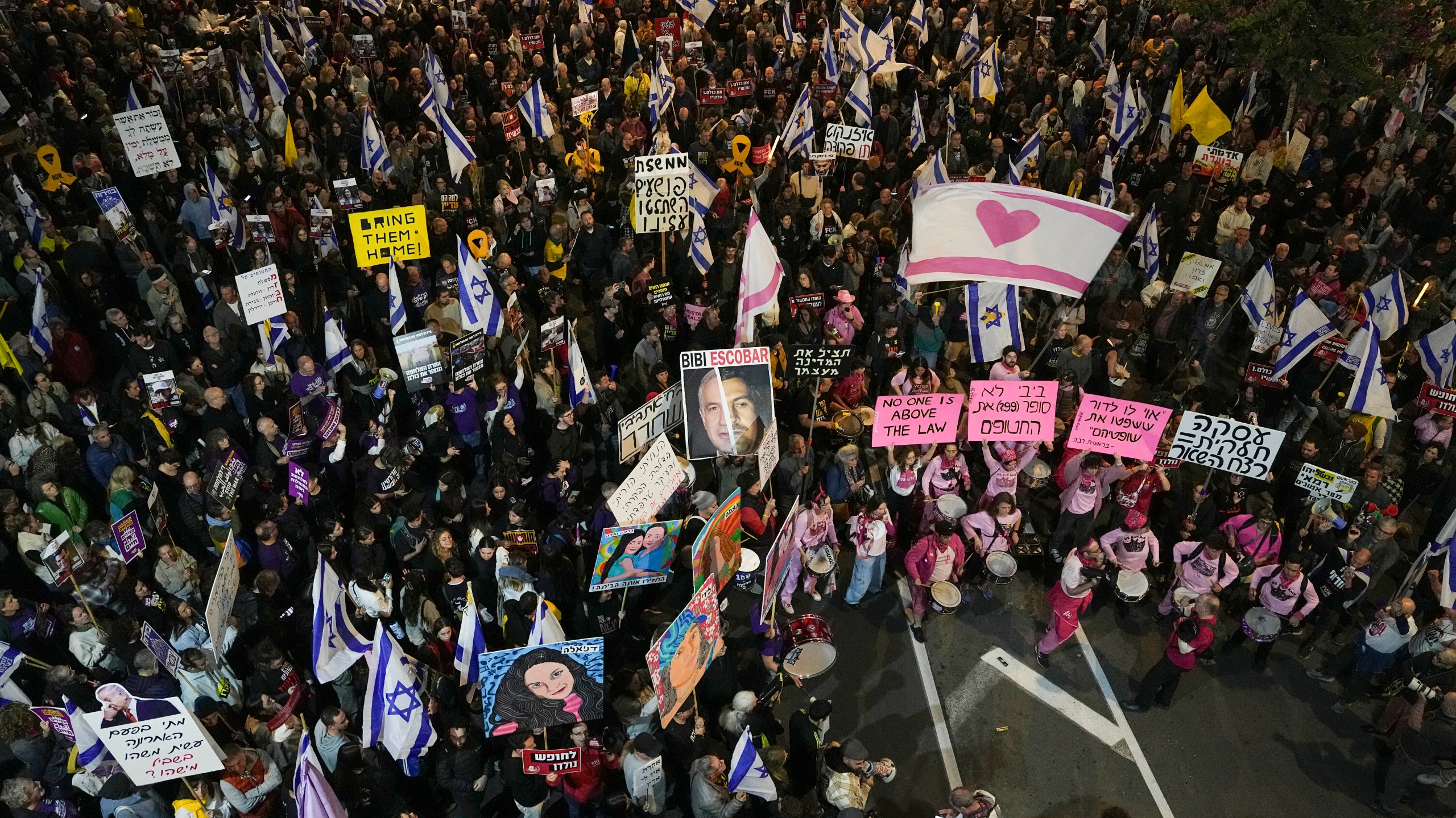 Israelis protest against Prime Minister Benjamin Netanyahu's government and call for the release of hostages held in the Gaza Strip by the Hamas militant group, in Tel Aviv, Israel, Saturday, Dec. 14, 2024. (AP Photo/Tsafrir Abayov)