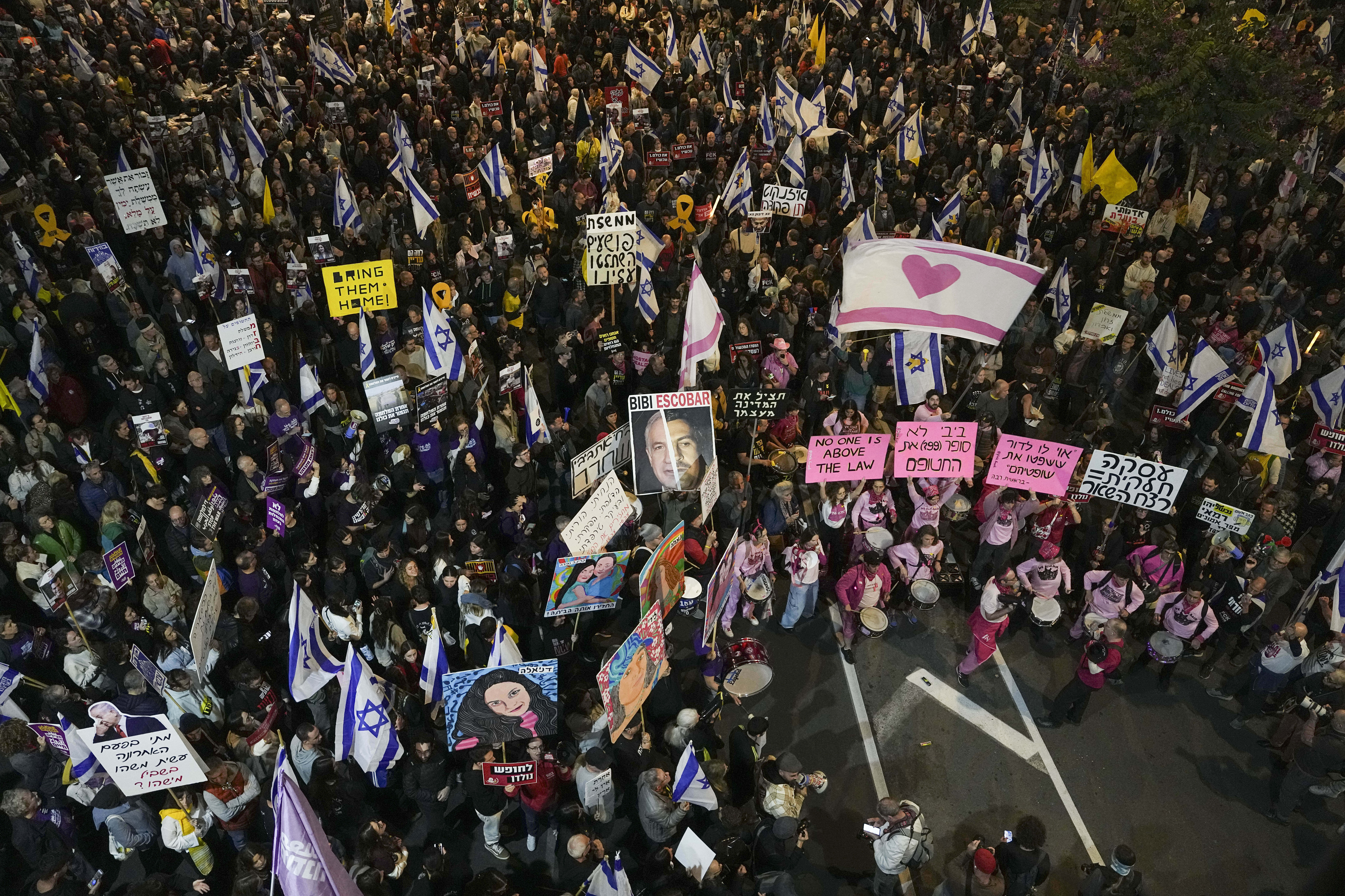 Israelis protest against Prime Minister Benjamin Netanyahu's government and call for the release of hostages held in the Gaza Strip by the Hamas militant group, in Tel Aviv, Israel, Saturday, Dec. 14, 2024. (AP Photo/Tsafrir Abayov)