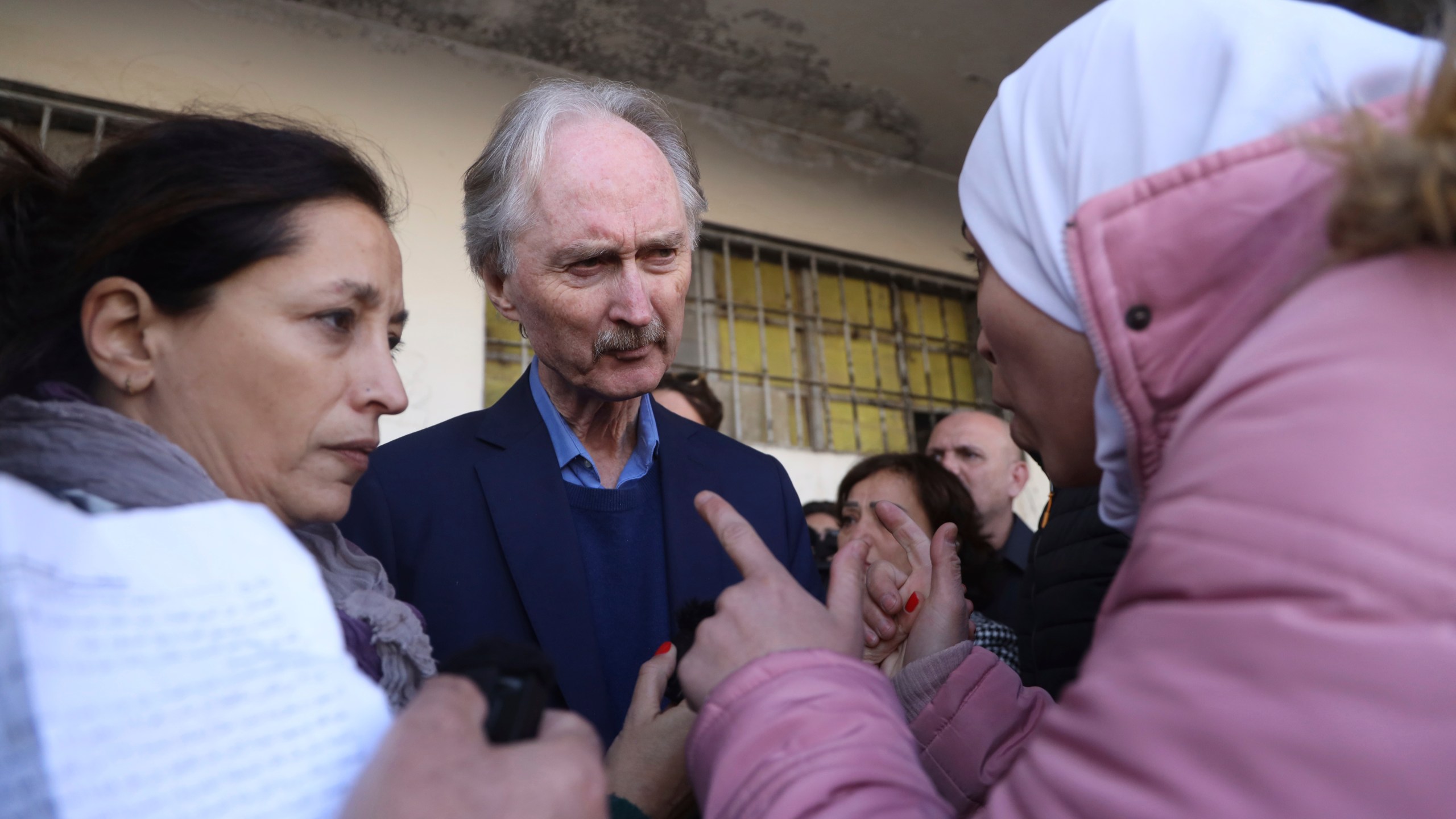 Geir Pederson, the United Nations' special envoy to Syria, center, listens to a woman who was looking for her missing relative in the Saydnaya prison, during his visit to the infamous Saydnaya military prison, in Saydnaya north of Damascus, Syria, Monday, Dec. 16, 2024. (AP Photo/Omar Albam)