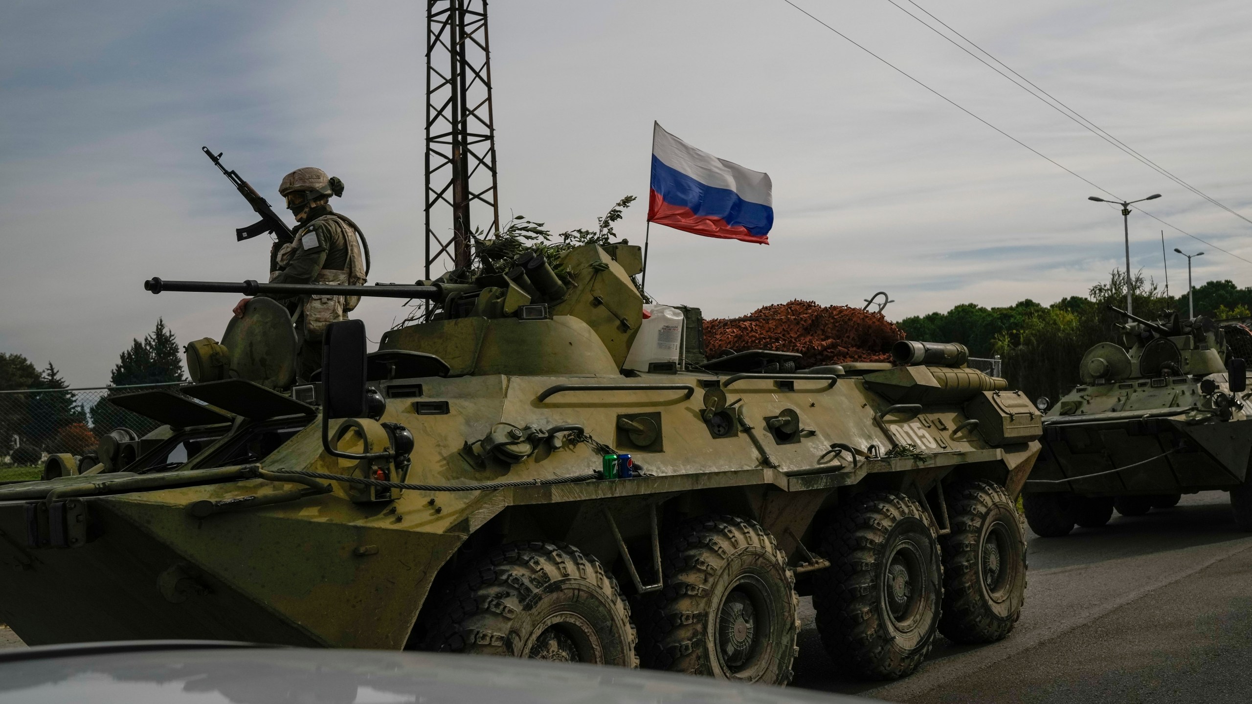 Russian army armoured vehicles drive near the Hmeimim Air Base, a Syrian airbase currently operated by Russia, located southeast of the city of Latakia in the town of Hmeimim, Syria, Monday Dec. 16, 2024.(AP Photo/Leo Correa)