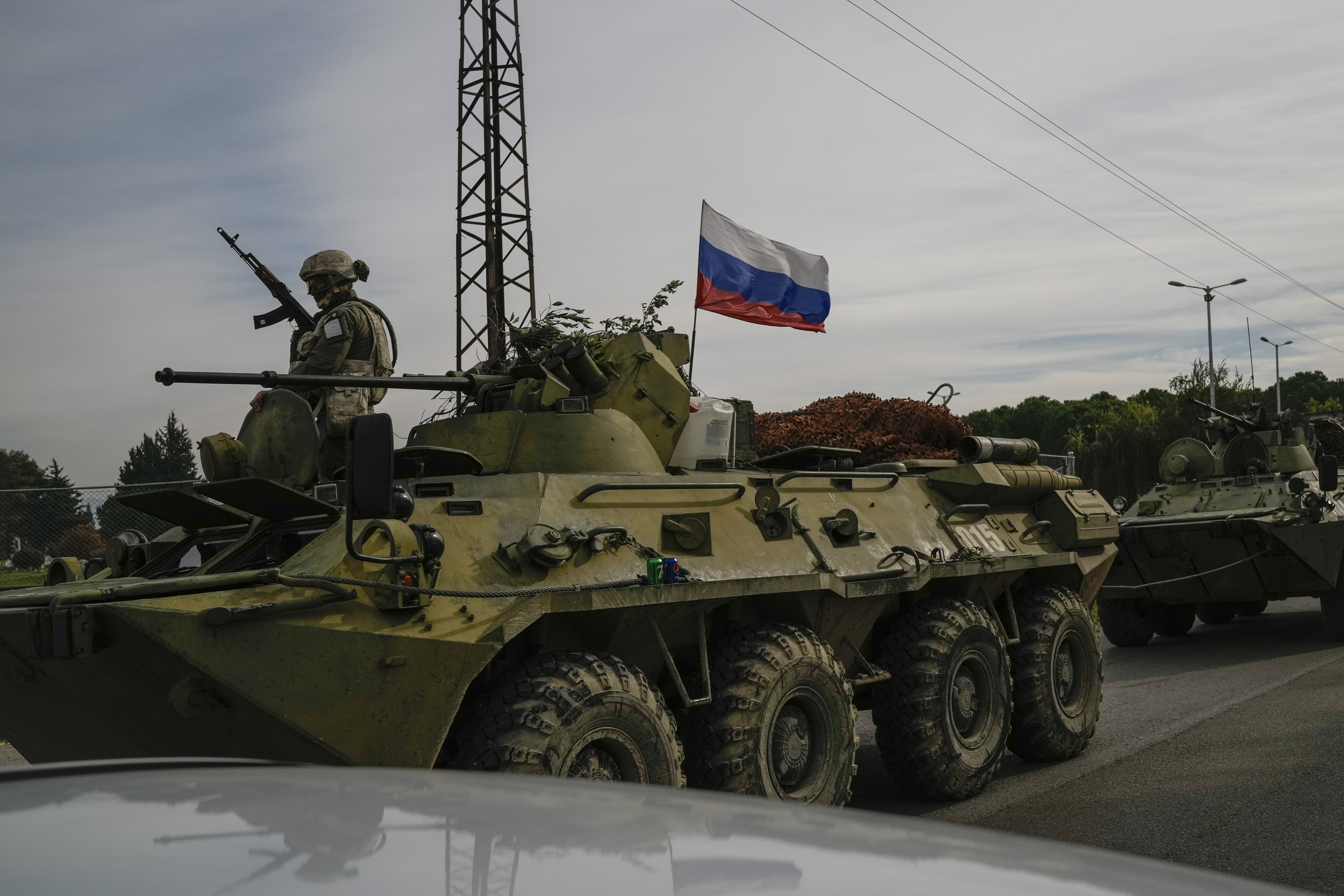 Russian army armoured vehicles drive near the Hmeimim Air Base, a Syrian airbase currently operated by Russia, located southeast of the city of Latakia in the town of Hmeimim, Syria, Monday Dec. 16, 2024.(AP Photo/Leo Correa)