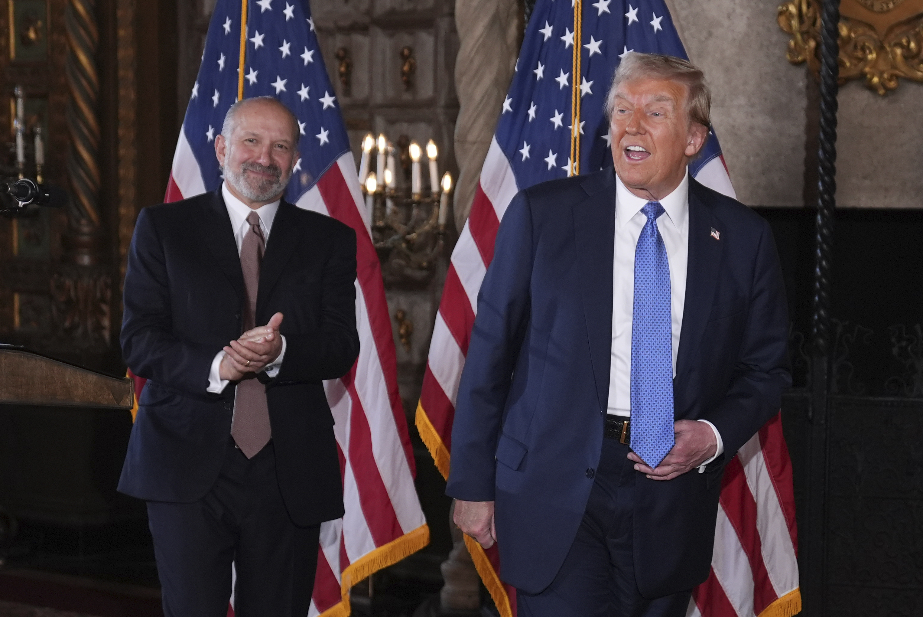 President-elect Donald Trump departs a news conference at Mar-a-Lago, Monday, Dec. 16, 2024, in Palm Beach, Fla., followed by Commerce Secretary nominee Howard Lutnick. (AP Photo/Evan Vucci)