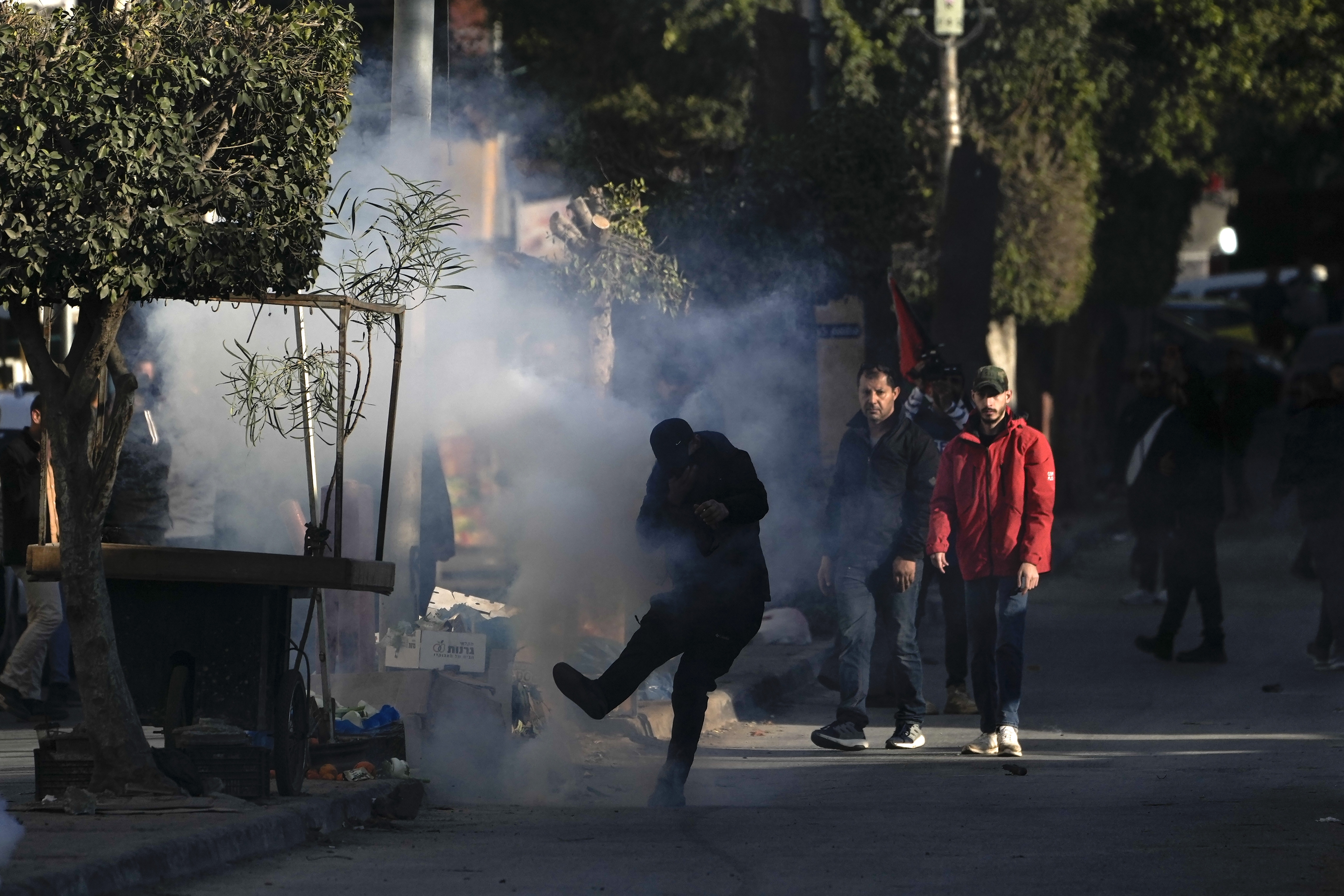 Palestinian youth clash with Palestinian security forces on the third day of a raid, outside the Jenin refugee camp in the Israeli-occupied West Bank, Monday, Dec. 16, 2024.(AP Photo/Majdi Mohammed).