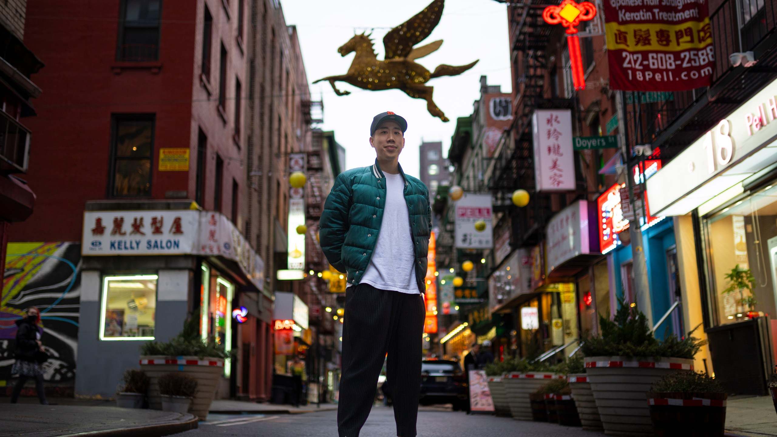 Karho Leung, 33, one of the founders of 12 Pell, a local barbershop, stands for his portrait on Pell Street in Manhattan's Chinatown neighborhood, Thursday, Jan. 25, 2024, in New York. Anchored in the Chinatown community and equally at home elsewhere in the city, Leung says he's "building the world that I want to live in… not asking for permission." (AP Photo/John Minchillo)