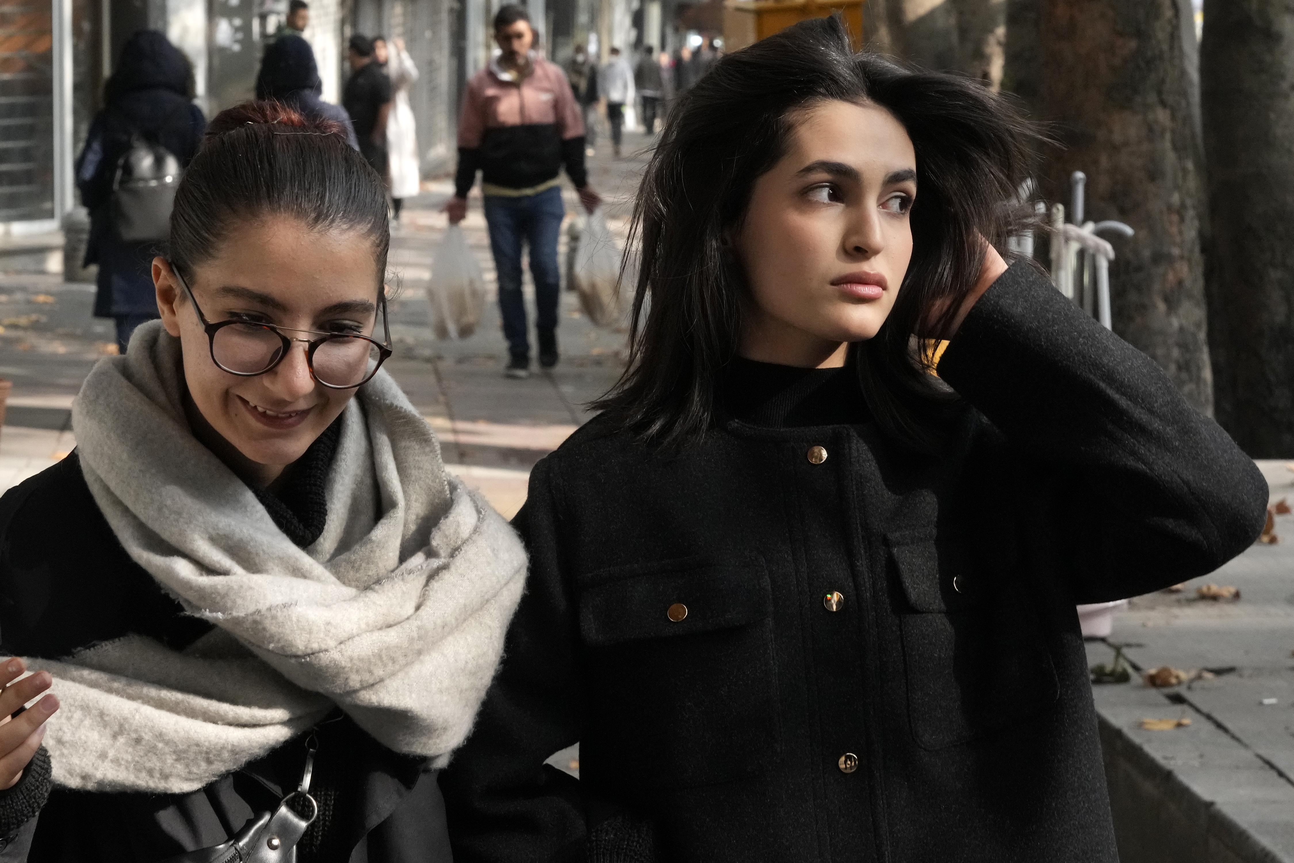 Iranian women, without wearing their mandatory Islamic headscarves, walk in northern Tehran, Iran, Friday, Nov. 15, 2024. (AP Photo/Vahid Salemi)