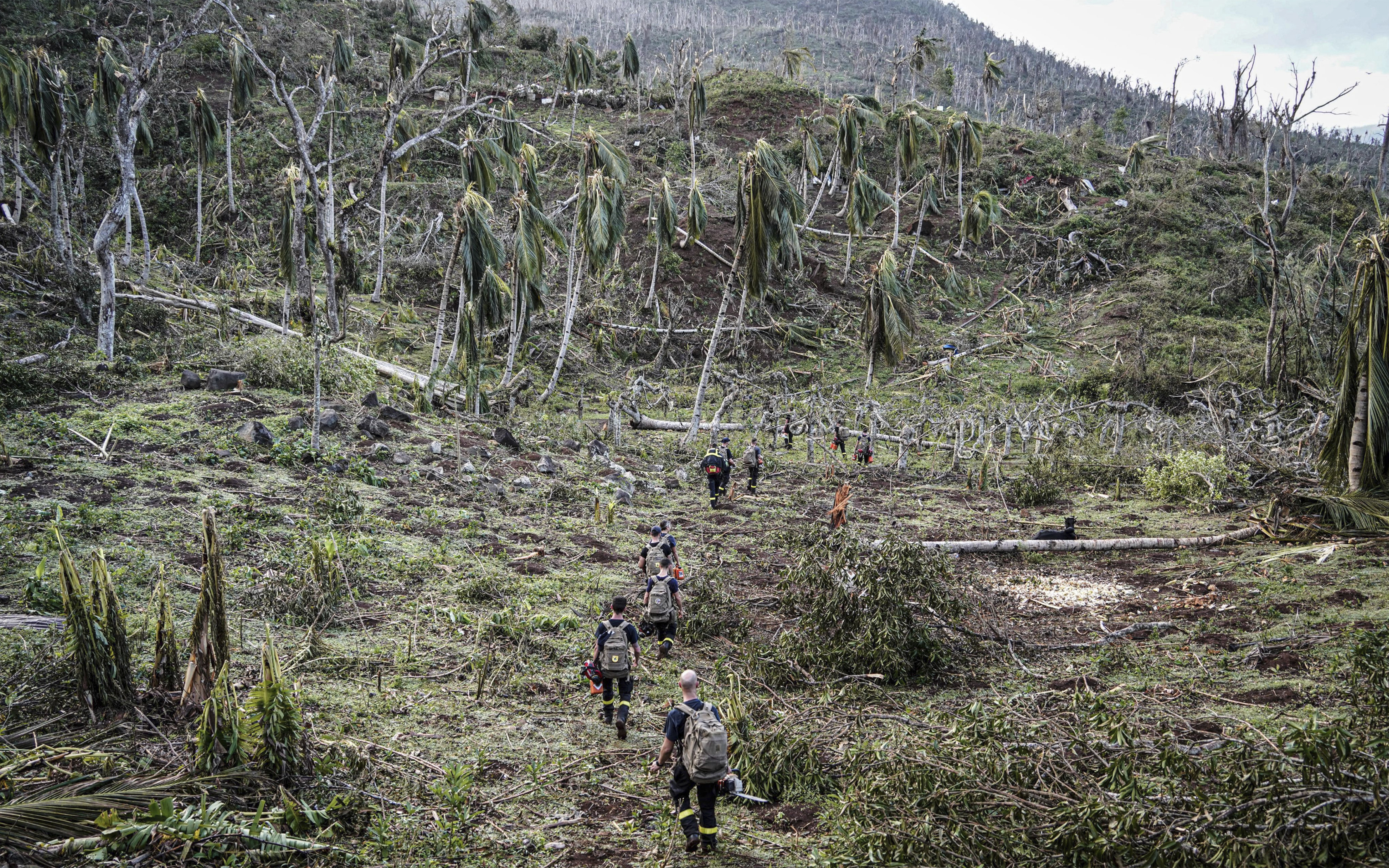 This photo provided by the French Interior Ministry shows rescue workers walking in a devastated area of the French territory of Mayotte in the Indian Ocean, after the island was battered by its worst cyclone in nearly a century, Tuesday Dec. 17, 2024. (Ministere de l'Interieur/Securite Civile via AP)