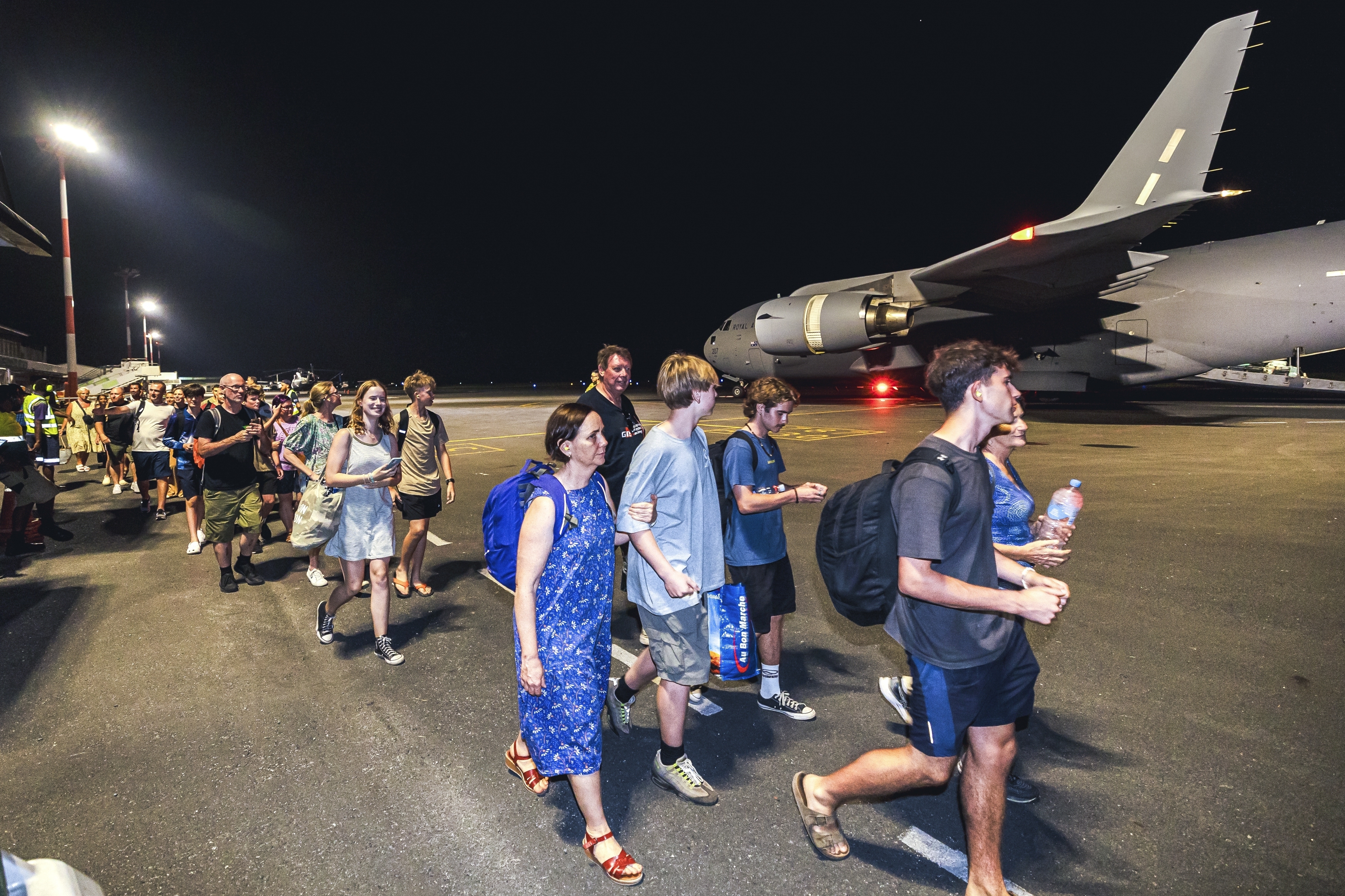 In this photo released by Australian Department of Defence, Australian citizens board a Royal Australian Air Force aircraft for a flight home from Bauerfield International Airport, Port Vila, Vanuatu, Wednesday, Dec. 18, 2024 following a powerful earthquake that struck just off the coast of Vanuatu in the South Pacific Ocean. (CPL Adam Abela/Australian Department of Defence via AP)