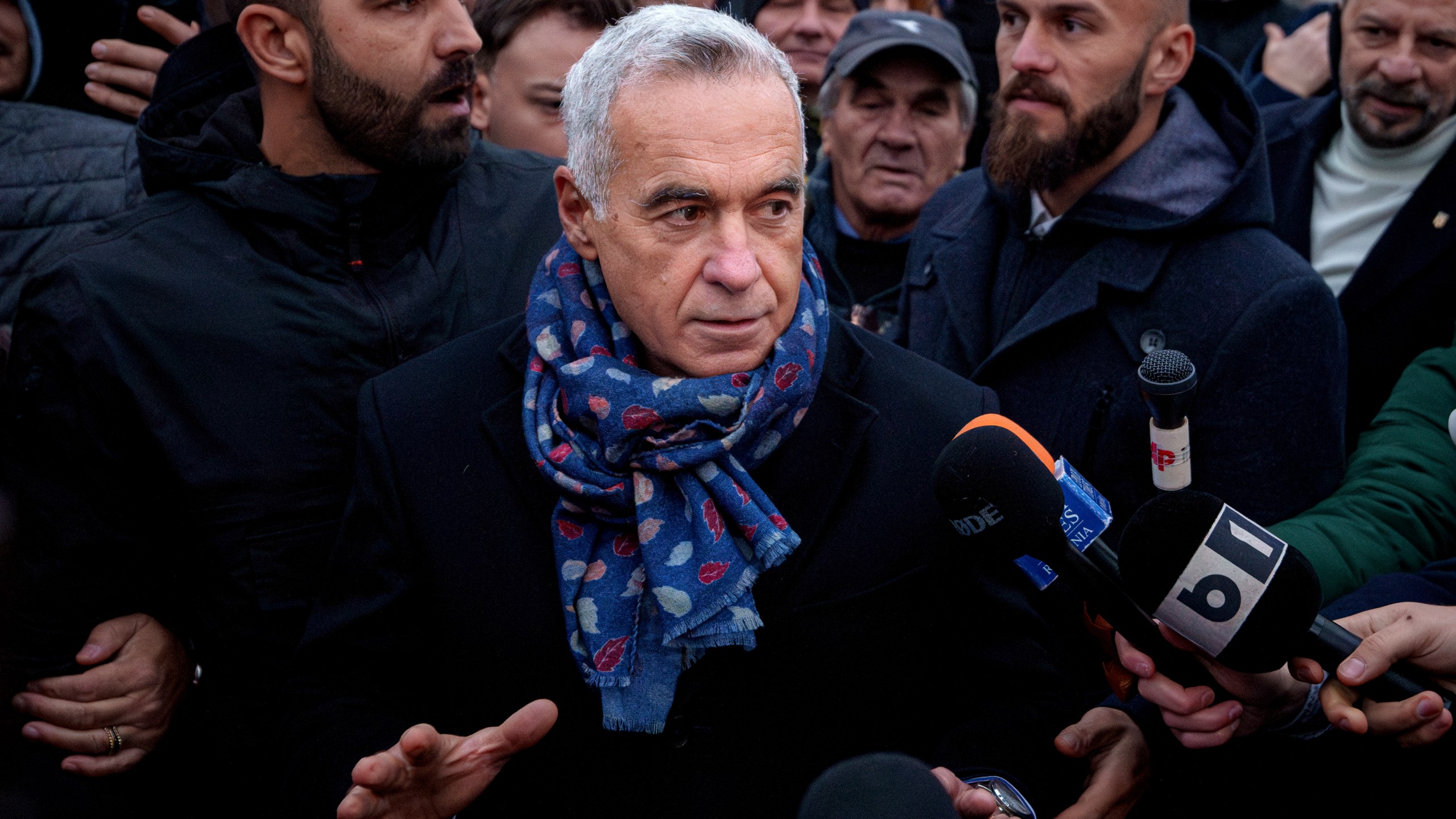 Calin Georgescu, an independent candidate for president who won the first round of presidential elections, speaks to media outside a voting station demanding to be allowed to vote after Romania's Constitutional Court annulled the first round of presidential elections, in Mogosoaia, Romania, Sunday, Dec. 8, 2024. (AP Photo/Andreea Alexandru)