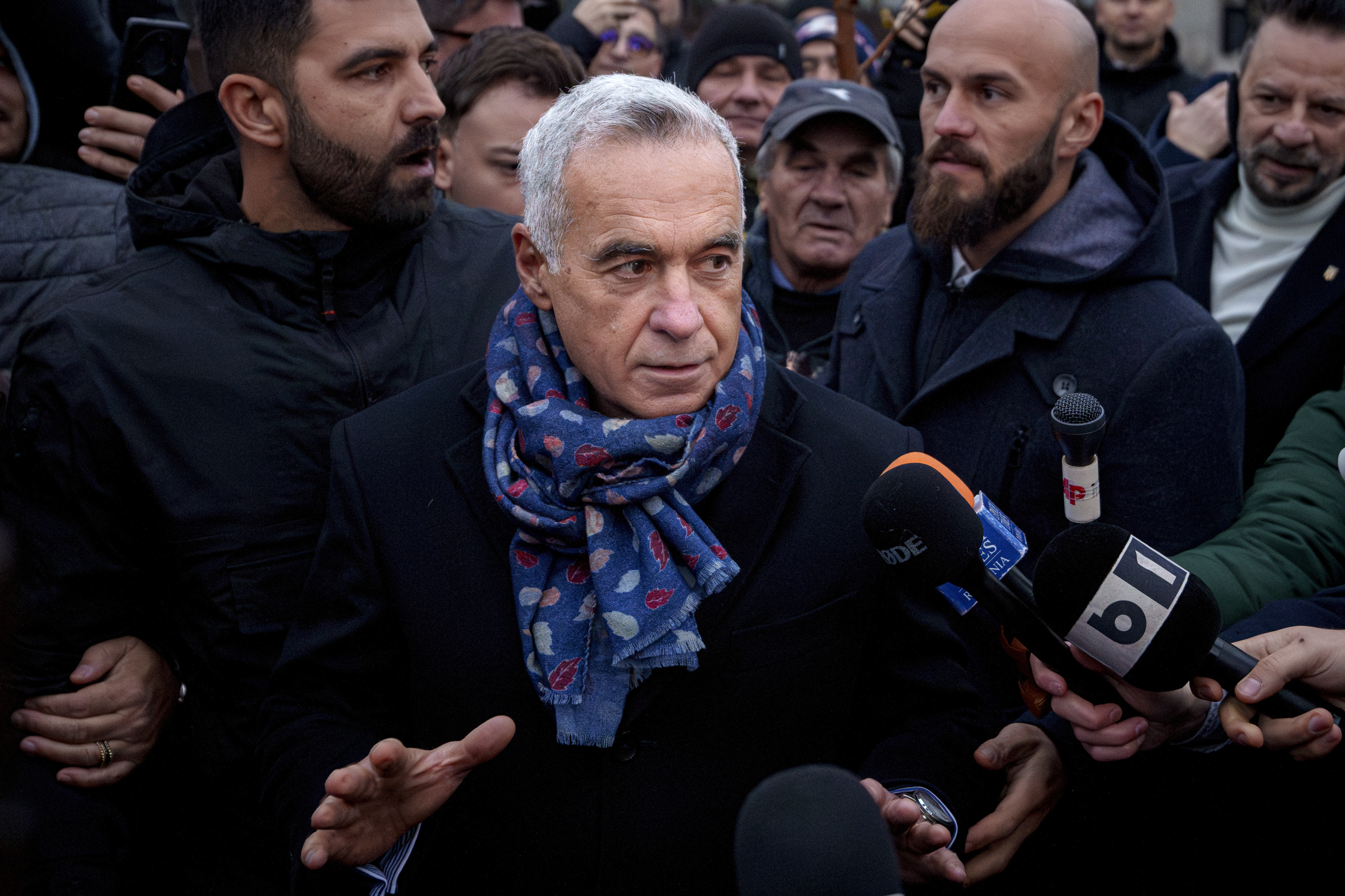 Calin Georgescu, an independent candidate for president who won the first round of presidential elections, speaks to media outside a voting station demanding to be allowed to vote after Romania's Constitutional Court annulled the first round of presidential elections, in Mogosoaia, Romania, Sunday, Dec. 8, 2024. (AP Photo/Andreea Alexandru)