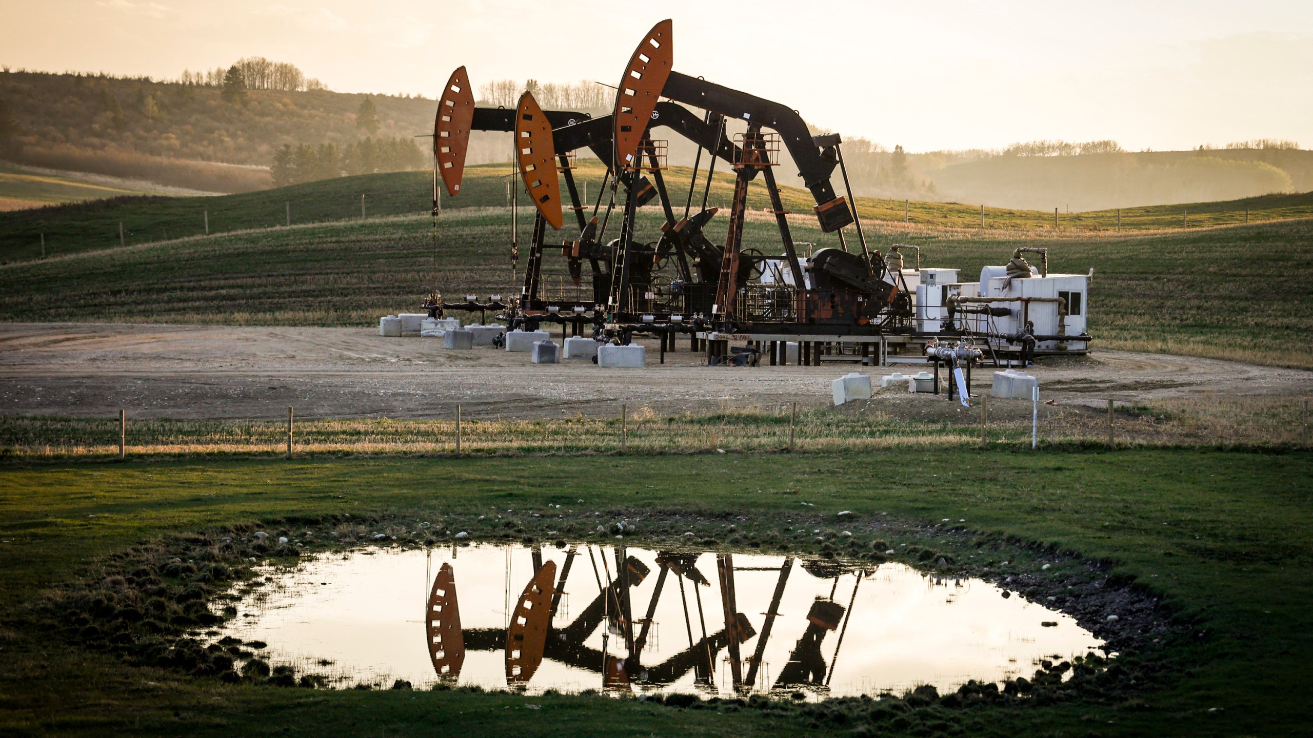 FILE - Pumpjacks draw out oil and gas from well heads as wildfire smoke hangs in the air near Calgary, Alberta, May 12, 2024. (Jeff McIntosh/The Canadian Press via AP, File)