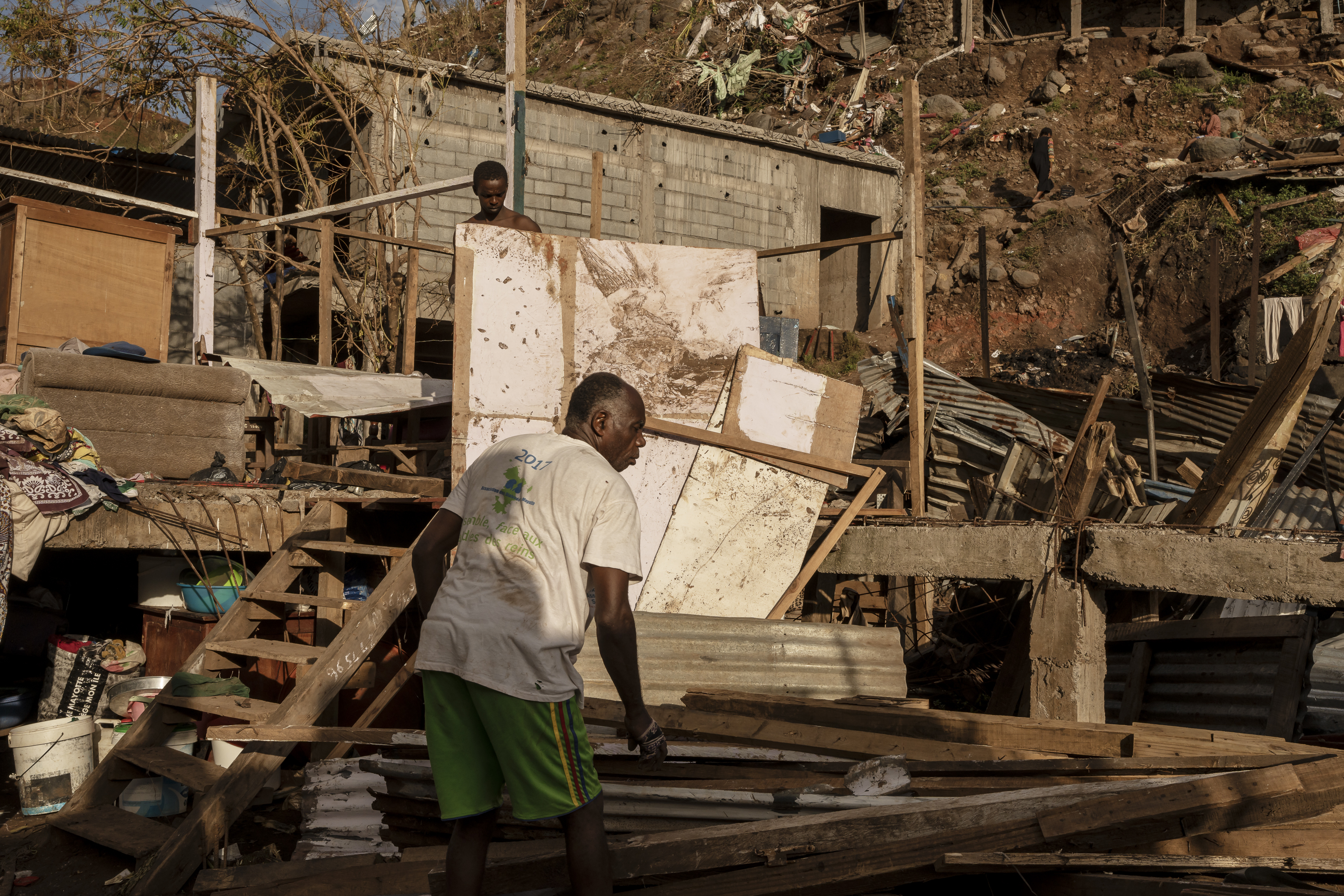 A man starts rebuilding his shack in the Kaweni slum on the outskirts of Mamoudzou, in the French Indian Ocean island of Mayotte, Thursday, Dec. 19, 2024, after Cyclone Chido. (AP Photo/Adrienne Surprenant)