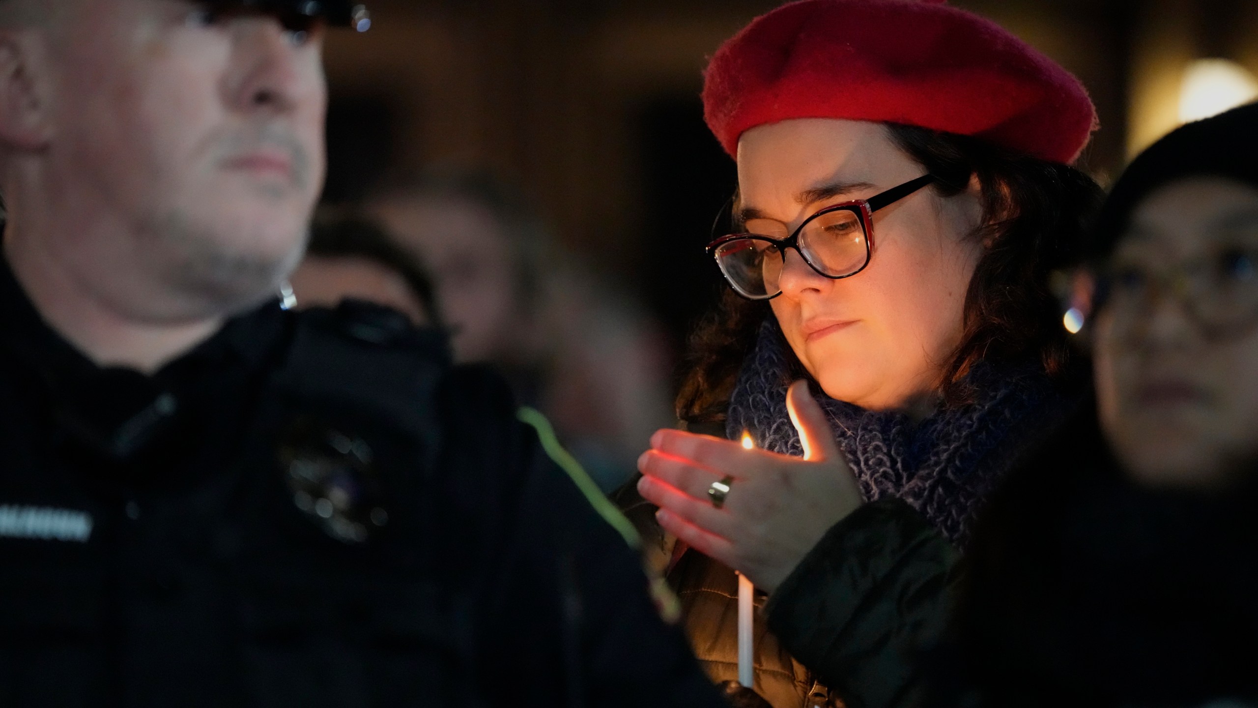 A supporter holds a candle during a candlelight vigil Tuesday, Dec. 17, 2024, outside the Wisconsin Capitol in Madison, Wis., following a shooting at the Abundant Life Christian School on Monday, Dec. 16. (AP Photo/Morry Gash)