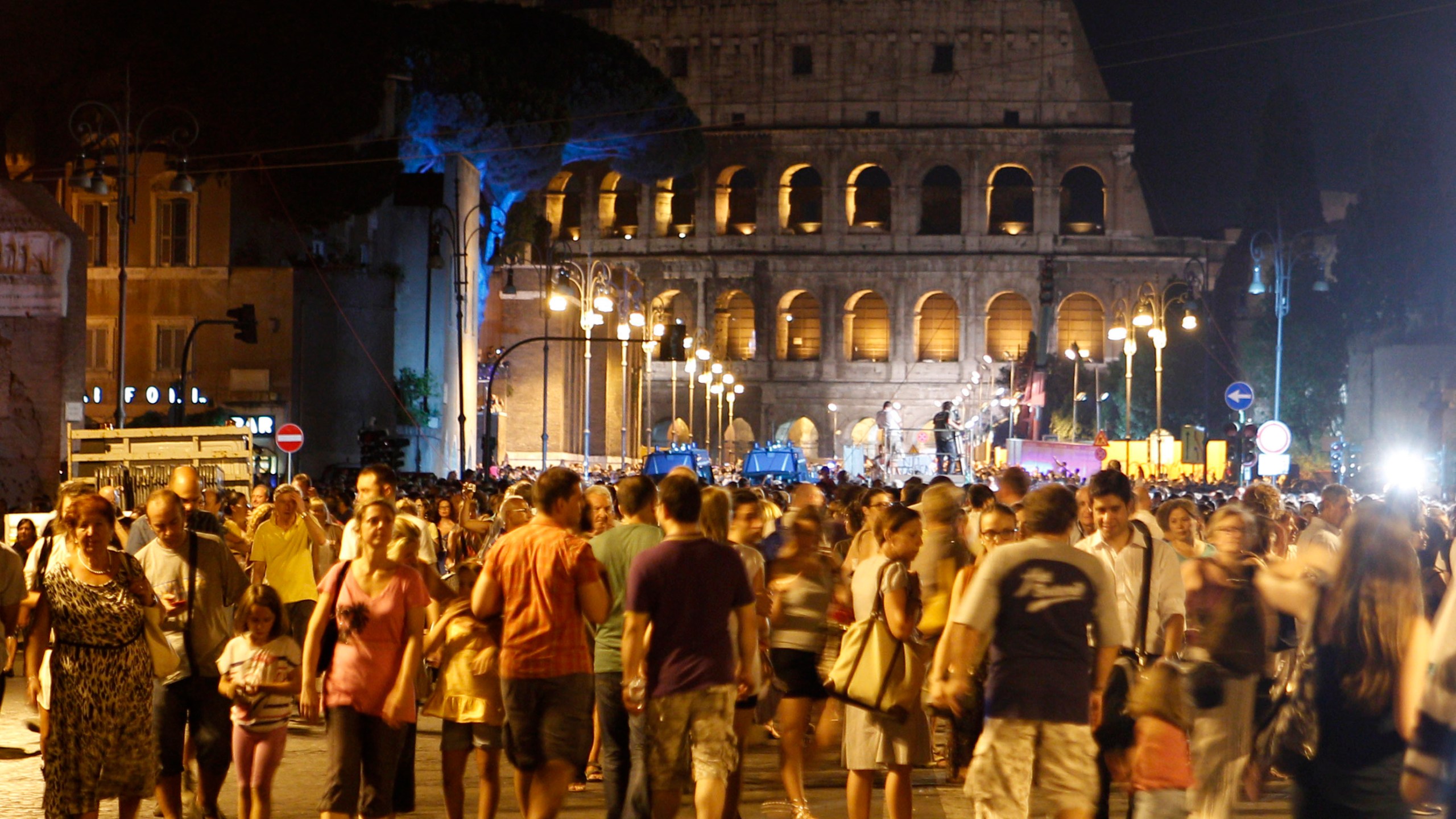 FILE - People gather at the Fori Imperiali avenue, with the Colosseum in the background, during an event celebrating the ban on private vehicles, in Rome, Saturday, Aug. 3, 2013. (AP Photo/Riccardo De Luca, File)