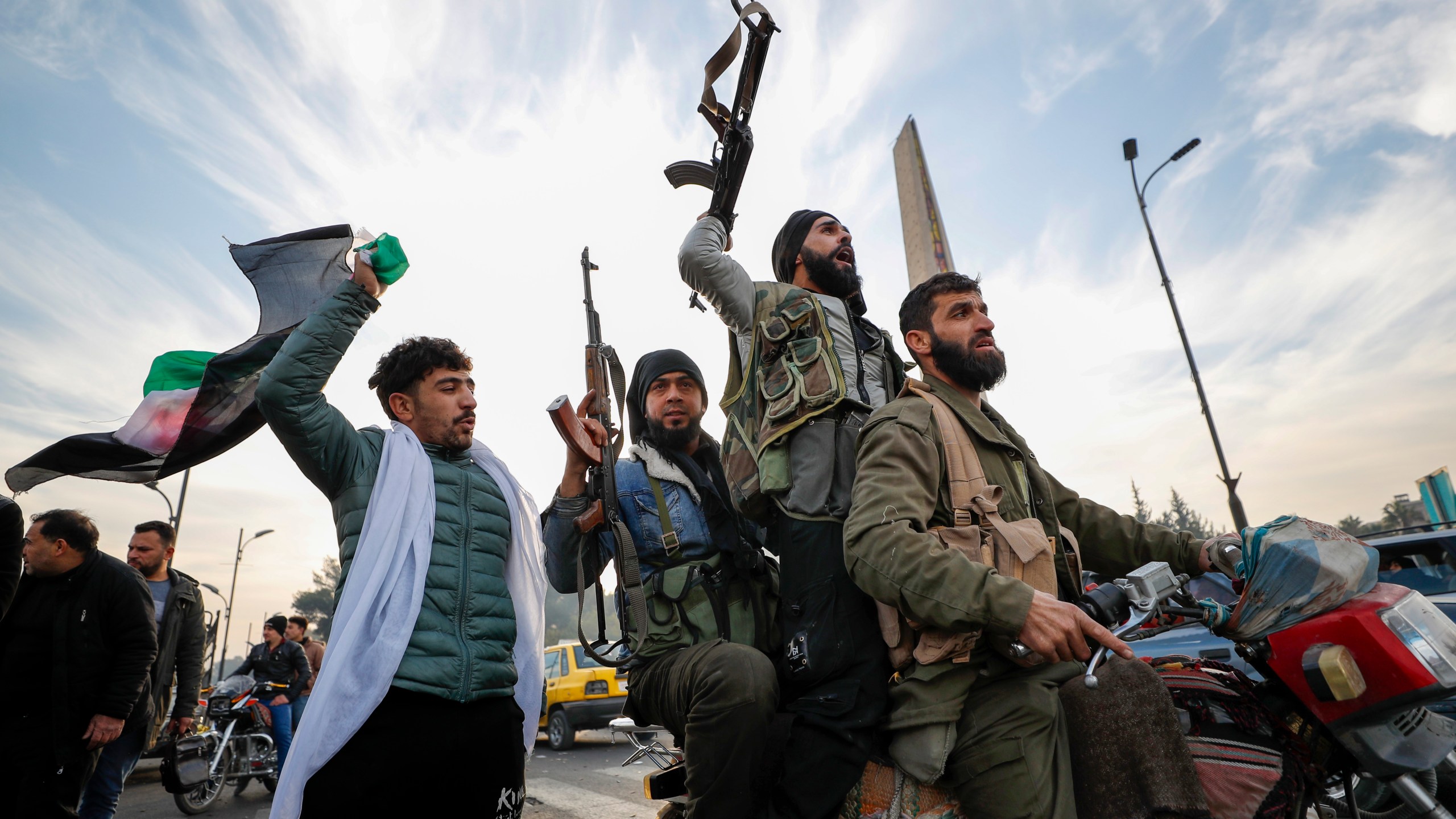 FILE - Syrian opposition fighters celebrate after the government of Bashar Assad collapses in Damascus, Syria, on Dec. 8, 2024. (AP Photo/Omar Sanadiki, File)