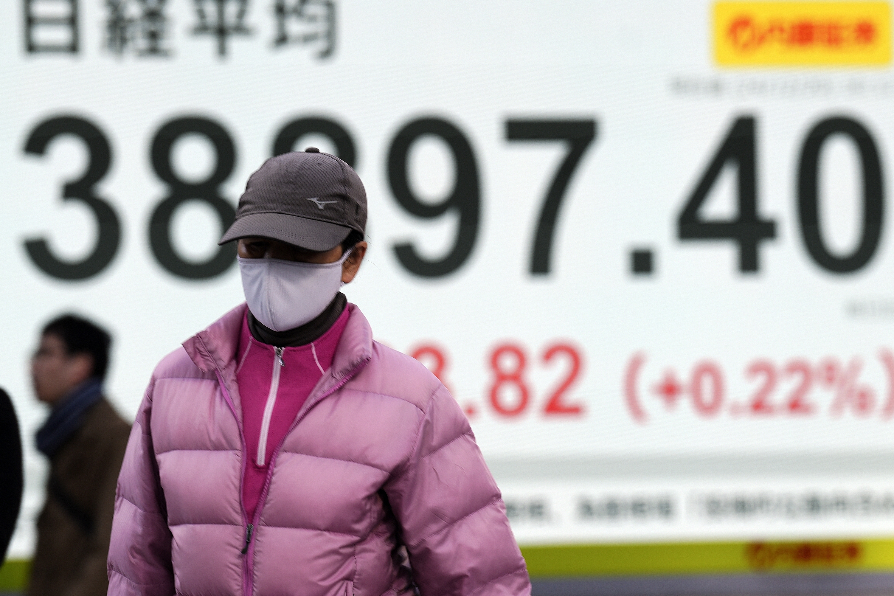 A person walks in front of an electronic stock board showing Japan's Nikkei index at a securities firm Friday, Dec. 20, 2024, in Tokyo. (AP Photo/Eugene Hoshiko)