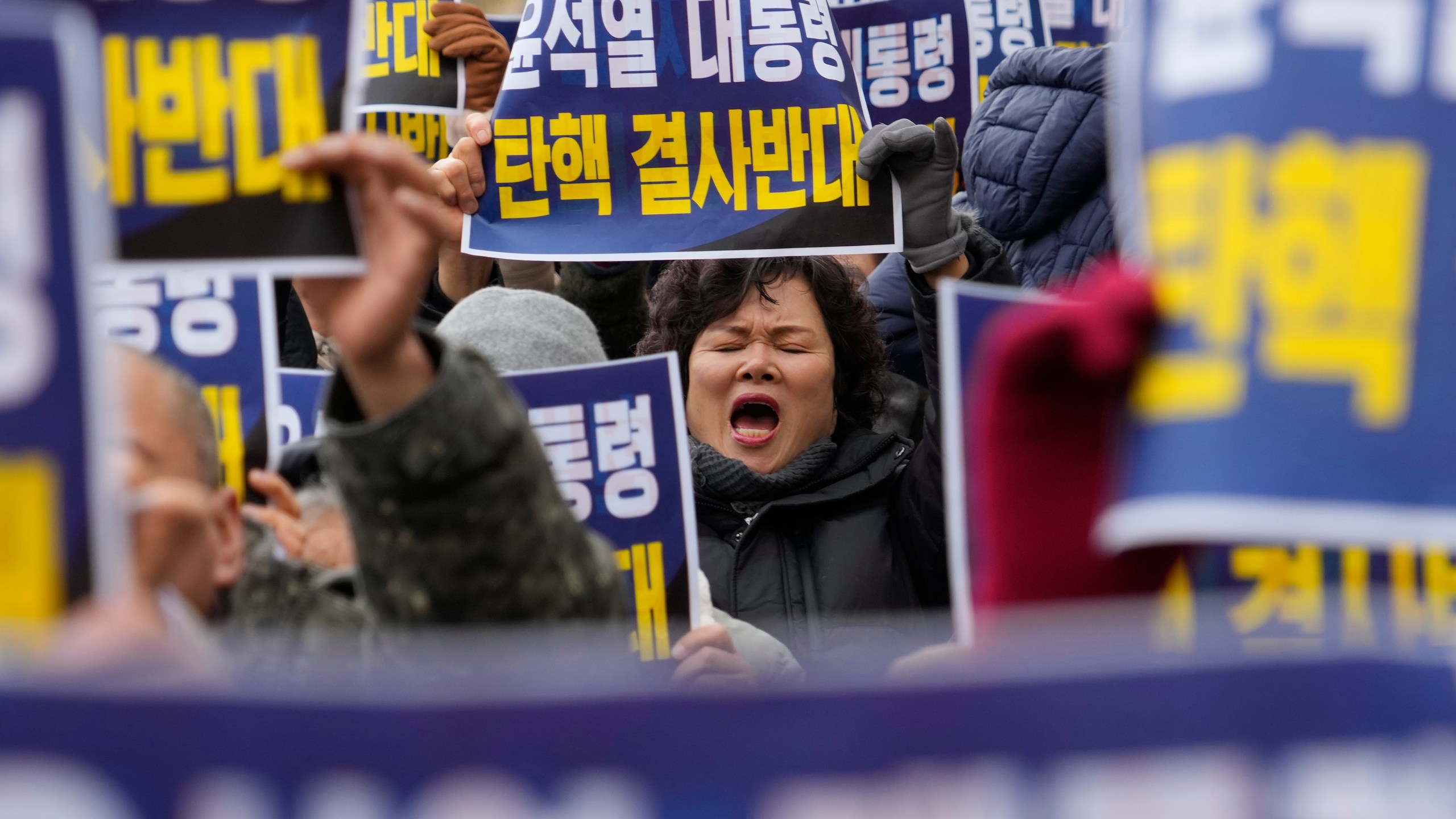 A supporter for impeached South Korean President Yoon Suk Yeol shouts slogans during a rally against his impeachment near the Constitutional Court in Seoul, South Korea, Friday, Dec. 20, 2024. The signs read "Oppose the impeachment of President Yoon Suk Yeol." (AP Photo/Ahn Young-joon)