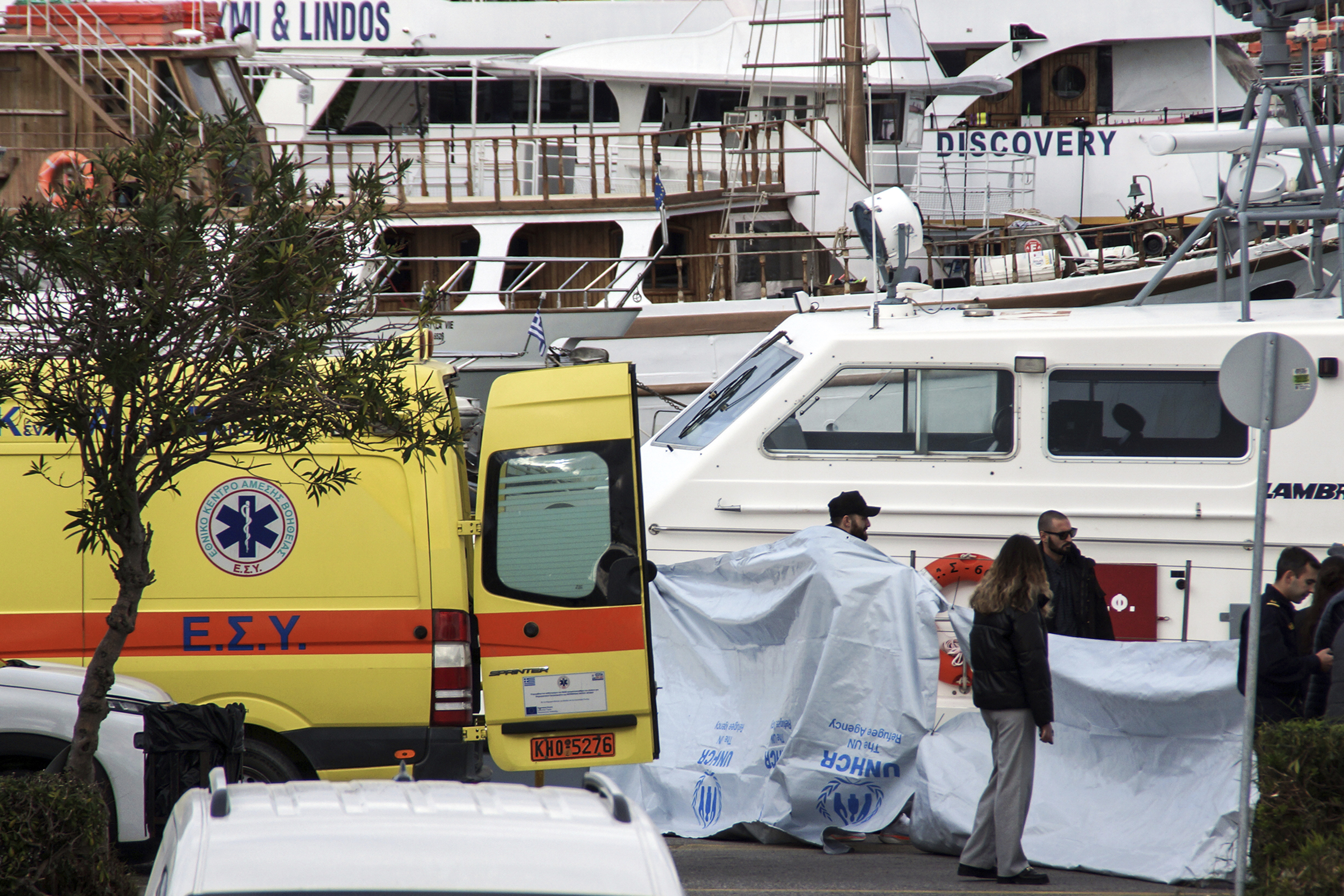 Coast guard officers cover the bodies after a speedboat carrying migrants has capsized, in the southeastern Aegean Sea island of Rhodes, Greece, Friday, Dec. 20, 2024. (Argyris Mantikos/Eurokinissi via AP)