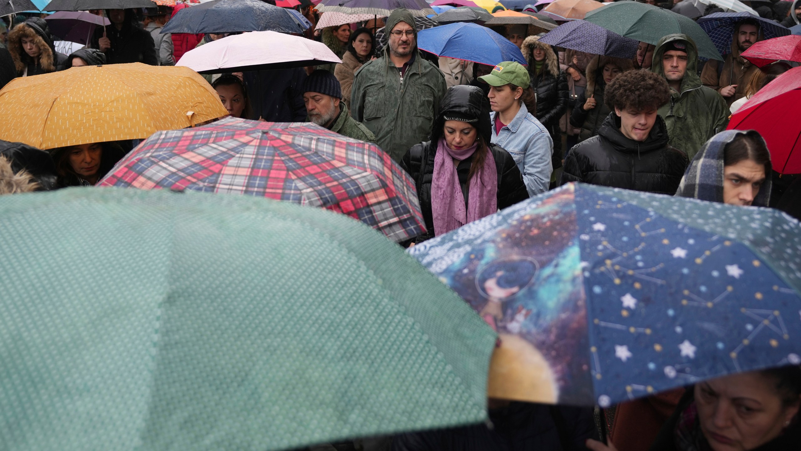 People stopping traffic, stand in silence during ongoing protests that erupted after a concrete canopy fell last month and killed 15 people, in Belgrade, Serbia, Friday, Dec. 20, 2024. (AP Photo/Darko Vojinovic)