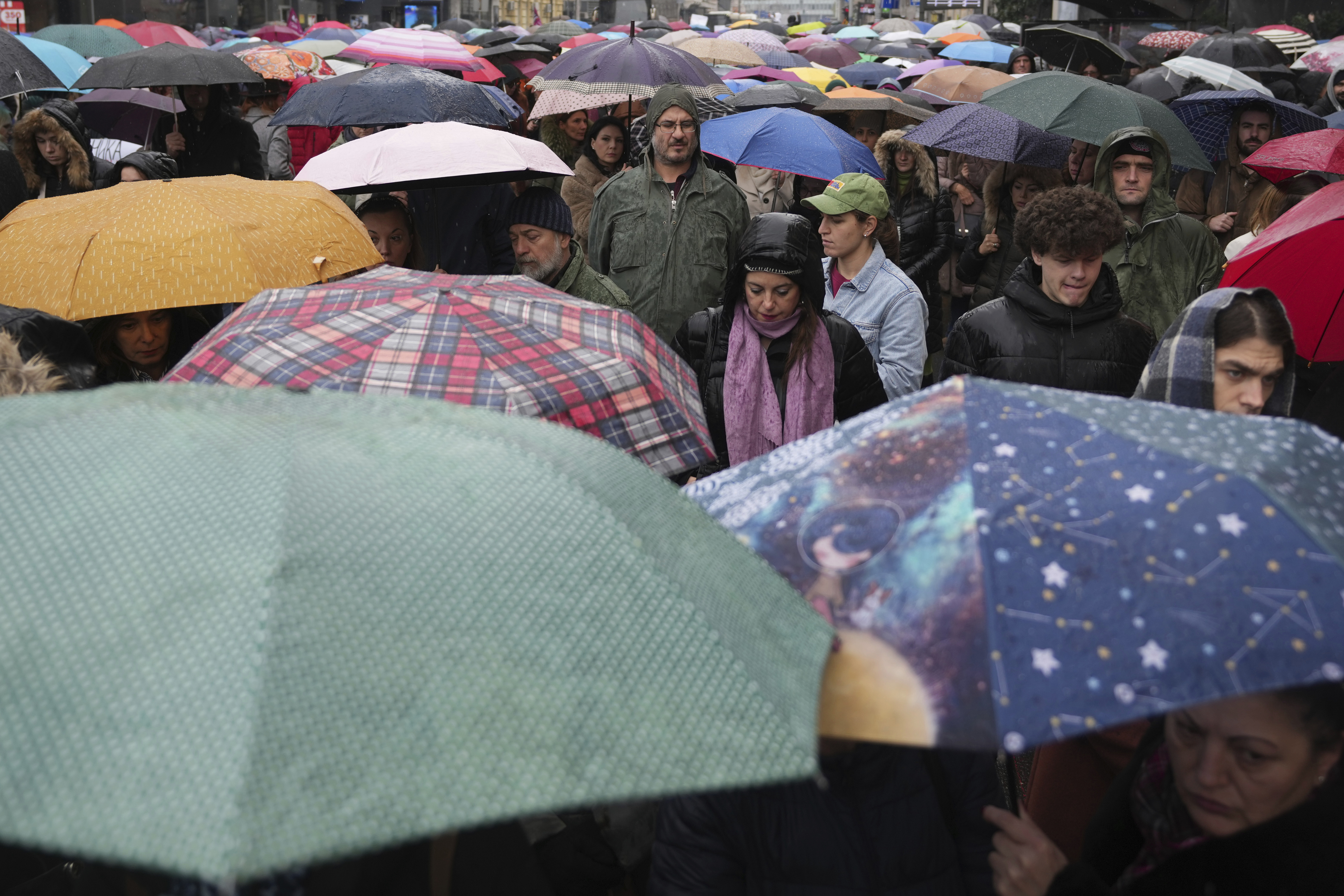 People stopping traffic, stand in silence during ongoing protests that erupted after a concrete canopy fell last month and killed 15 people, in Belgrade, Serbia, Friday, Dec. 20, 2024. (AP Photo/Darko Vojinovic)