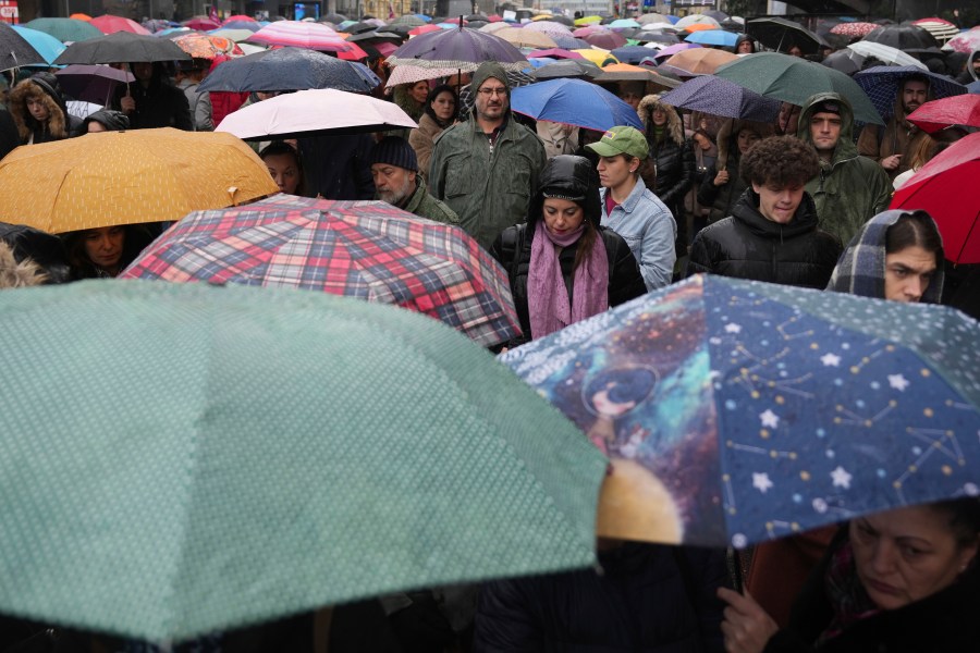 People stopping traffic, stand in silence during ongoing protests that erupted after a concrete canopy fell last month and killed 15 people, in Belgrade, Serbia, Friday, Dec. 20, 2024. (AP Photo/Darko Vojinovic)