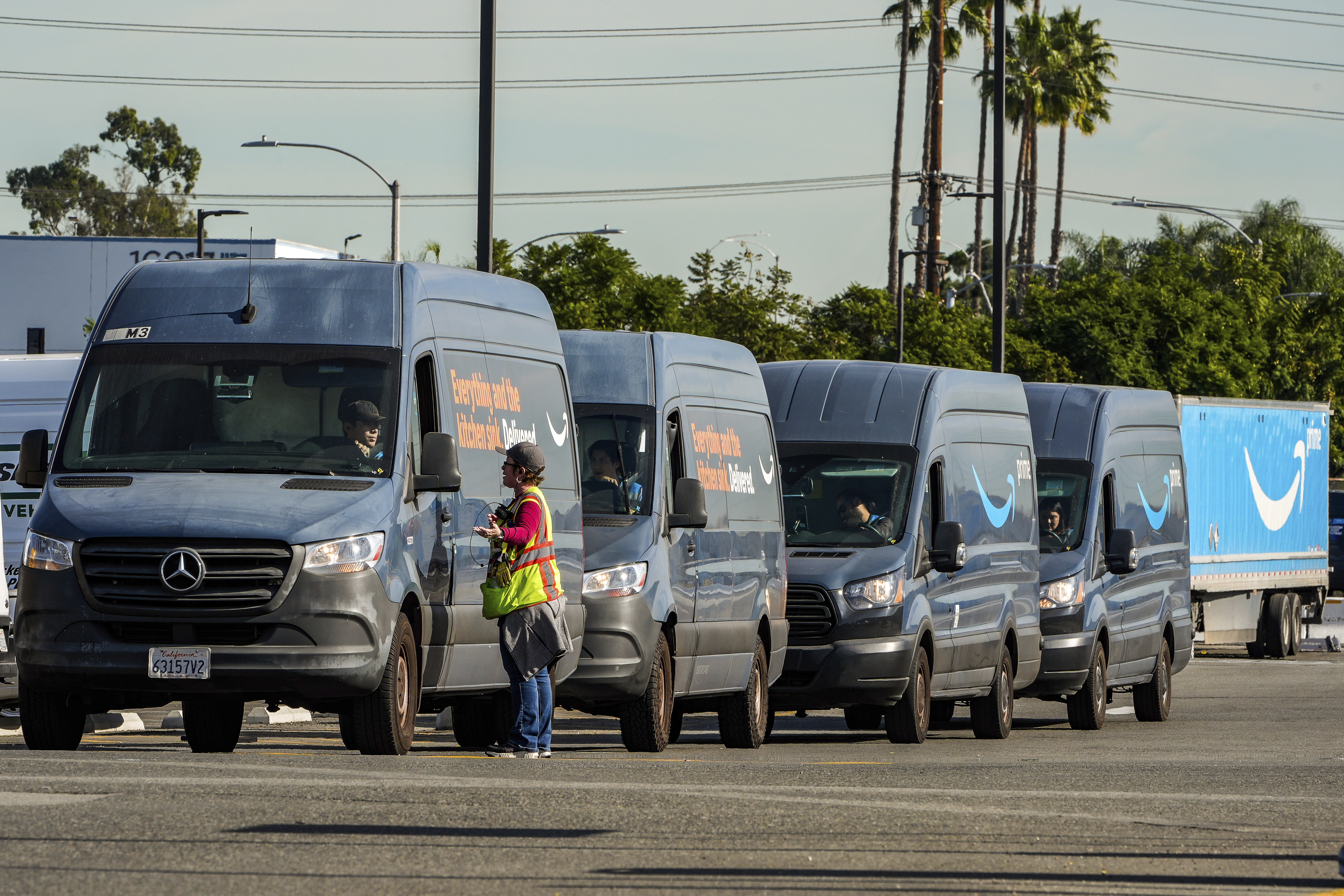 Amazon drivers wait in line before departing to deliver goods as Amazon workers picket outside the gates of an Amazon Fulfillment Center, Thursday, Dec. 19, 2024, in City of Industry, Calif. (AP Photo/Damian Dovarganes)