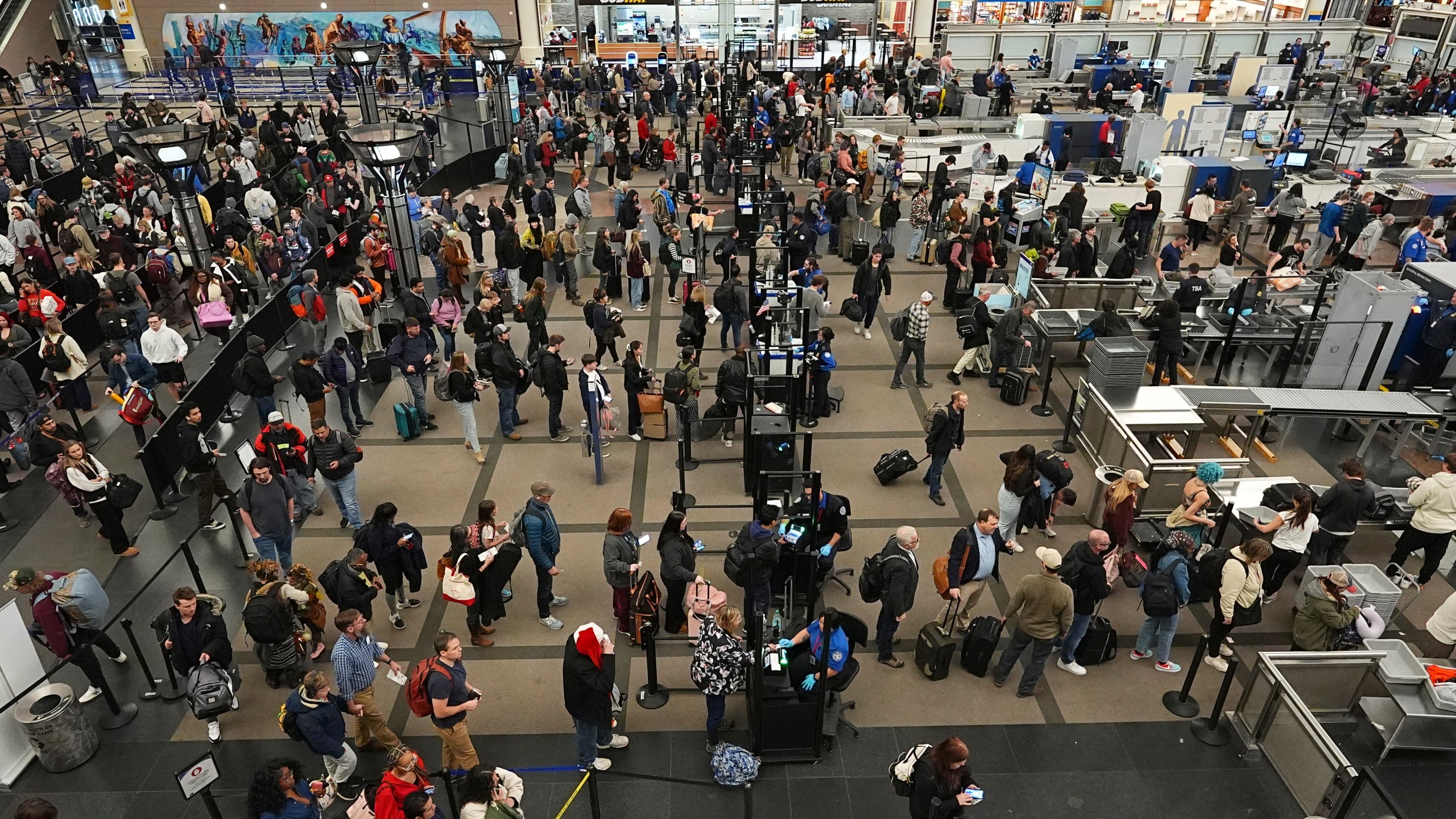 Travelers wade through the south security checkpoint in Denver International Airport Thursday, Dec. 19, 2024, in Denver. (AP Photo/David Zalubowski)