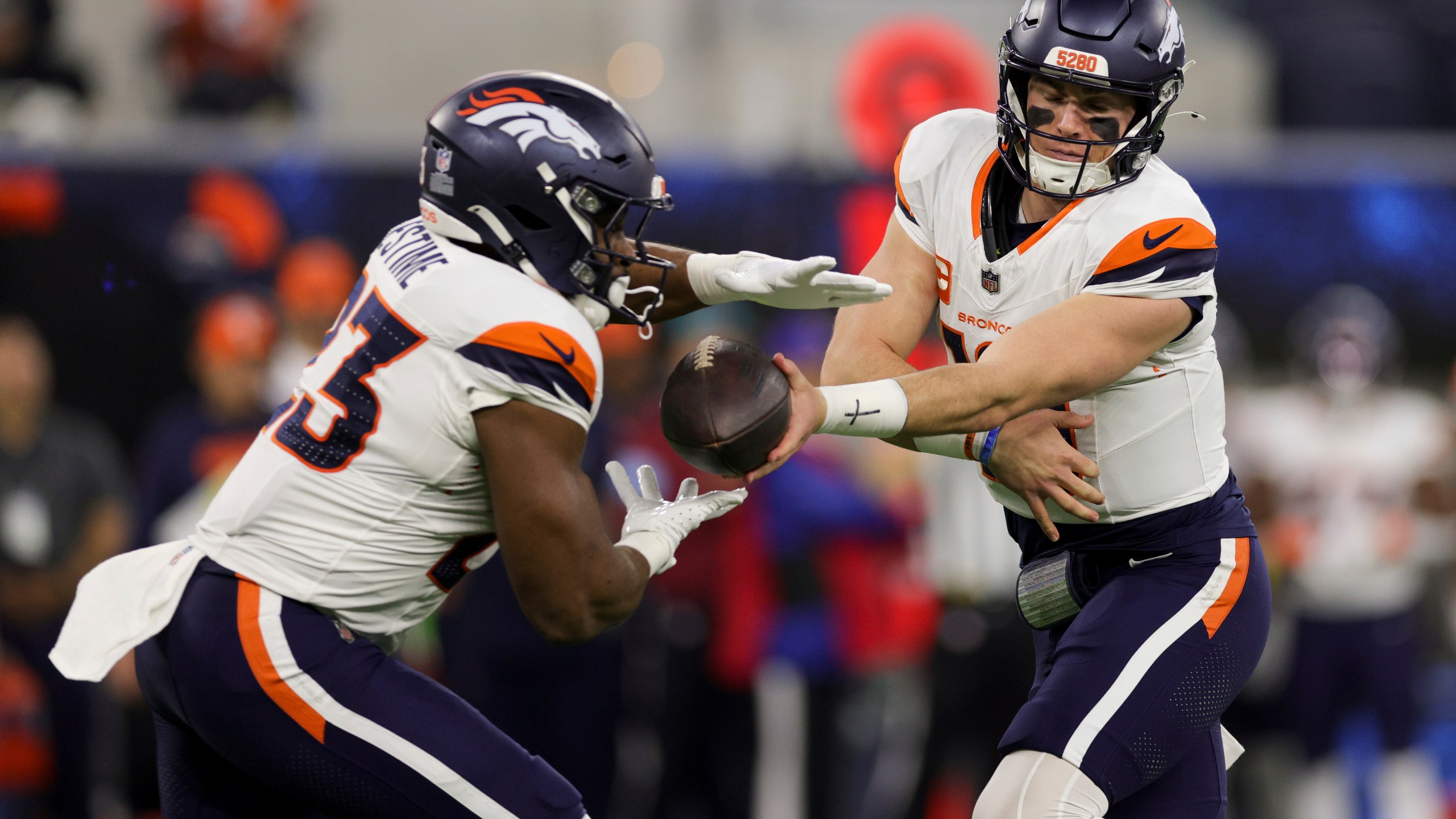 Denver Broncos quarterback Bo Nix, right, hands off to running back Audric Estime (23) during the first half an NFL football game against the Los Angeles Chargers, Thursday, Dec. 19, 2024, in Inglewood, Calif. (AP Photo/Ryan Sun)