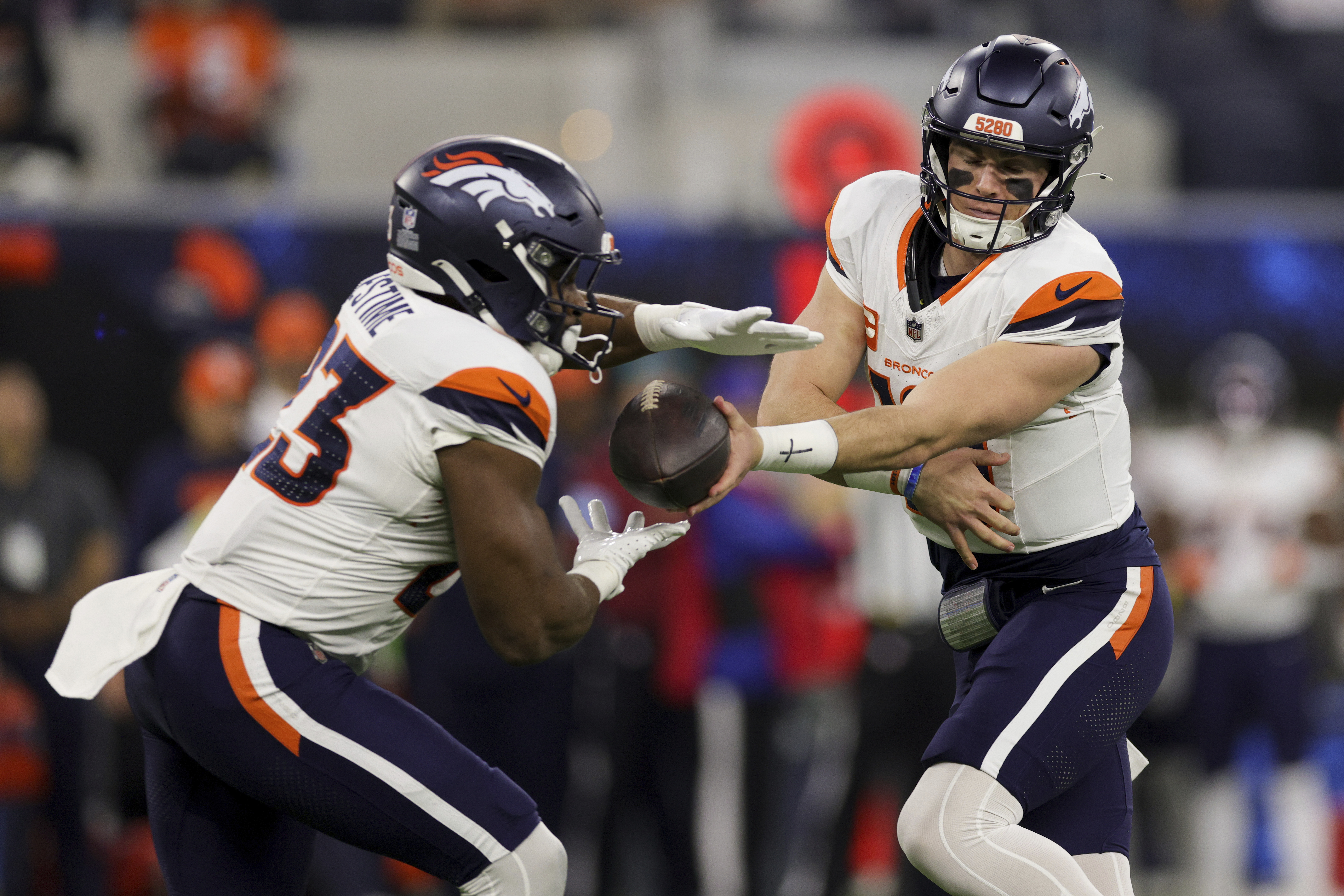 Denver Broncos quarterback Bo Nix, right, hands off to running back Audric Estime (23) during the first half an NFL football game against the Los Angeles Chargers, Thursday, Dec. 19, 2024, in Inglewood, Calif. (AP Photo/Ryan Sun)