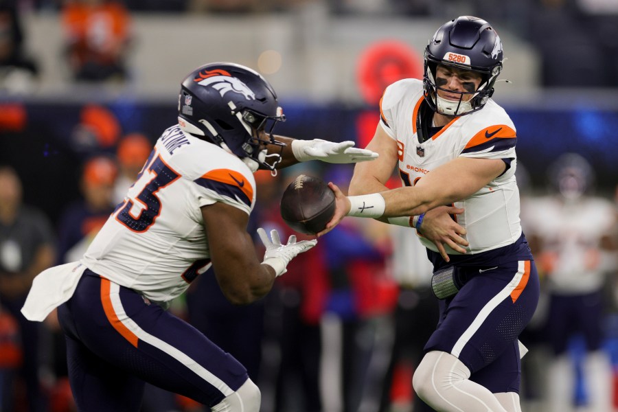 Denver Broncos quarterback Bo Nix, right, hands off to running back Audric Estime (23) during the first half an NFL football game against the Los Angeles Chargers, Thursday, Dec. 19, 2024, in Inglewood, Calif. (AP Photo/Ryan Sun)