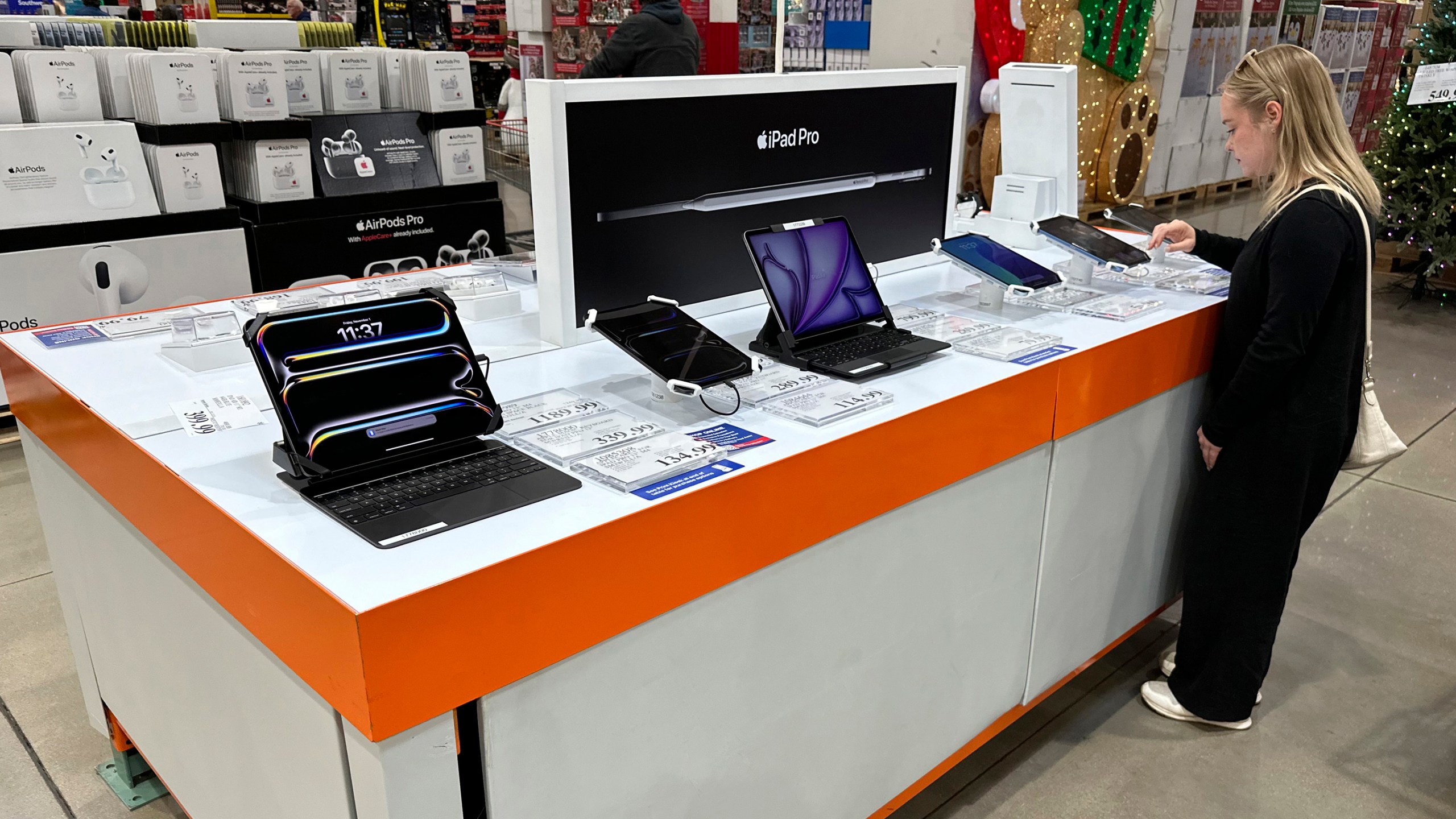 FILE - A consumer looks over an IPad on display in a Costco warehouse Friday, Nov. 1, 2024, in Sheridan, Colo. (AP Photo/David Zalubowski, File)