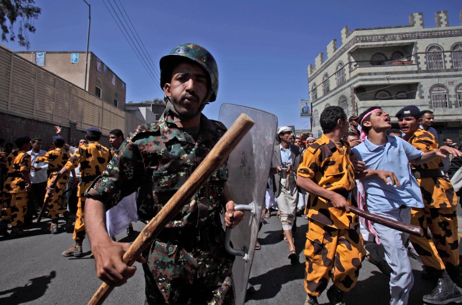 FILE - Yemeni riot police charge towards anti-government protesters during a demonstration demanding the resignation of President Ali Abdullah Saleh in Sanaa, Yemen, on Feb. 18, 2011. (AP Photo/Muhammed Muheisen, File)