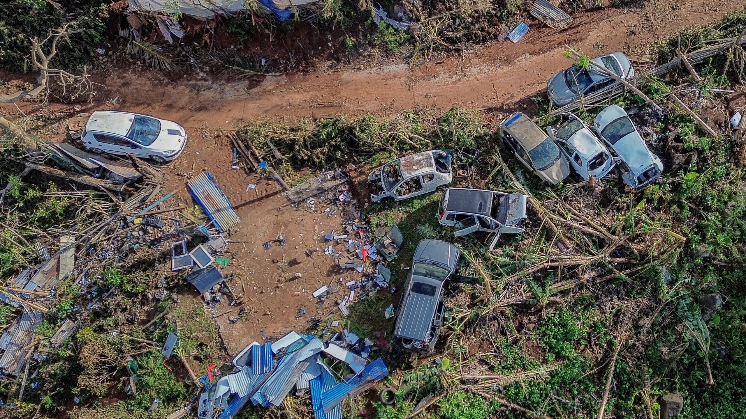 Drone view of destroyed cars in Mirereni, Mayotte, Friday, Dec. 20, 2024. (AP Photo/Adrienne Surprenant)