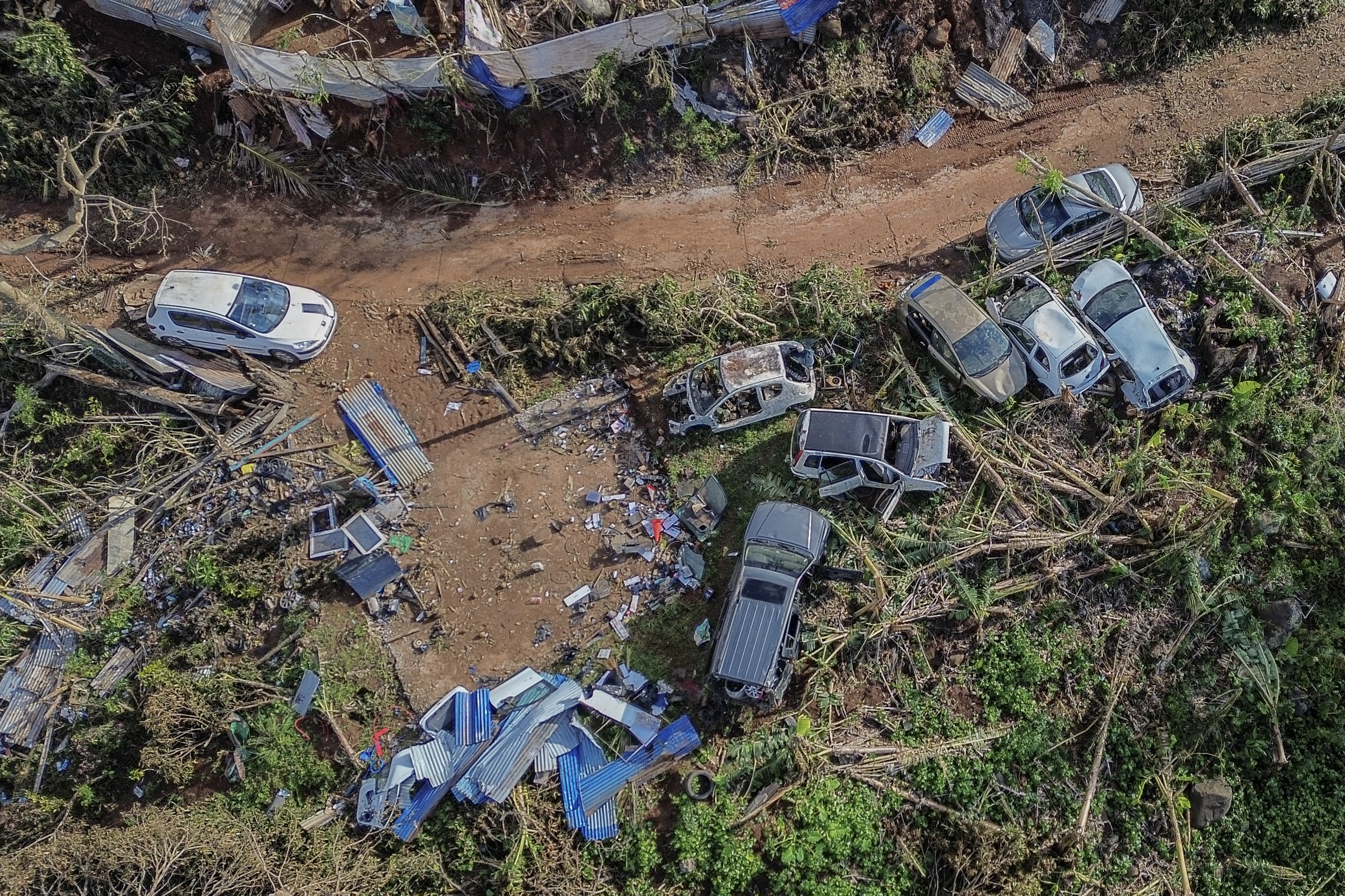 Drone view of destroyed cars in Mirereni, Mayotte, Friday, Dec. 20, 2024. (AP Photo/Adrienne Surprenant)