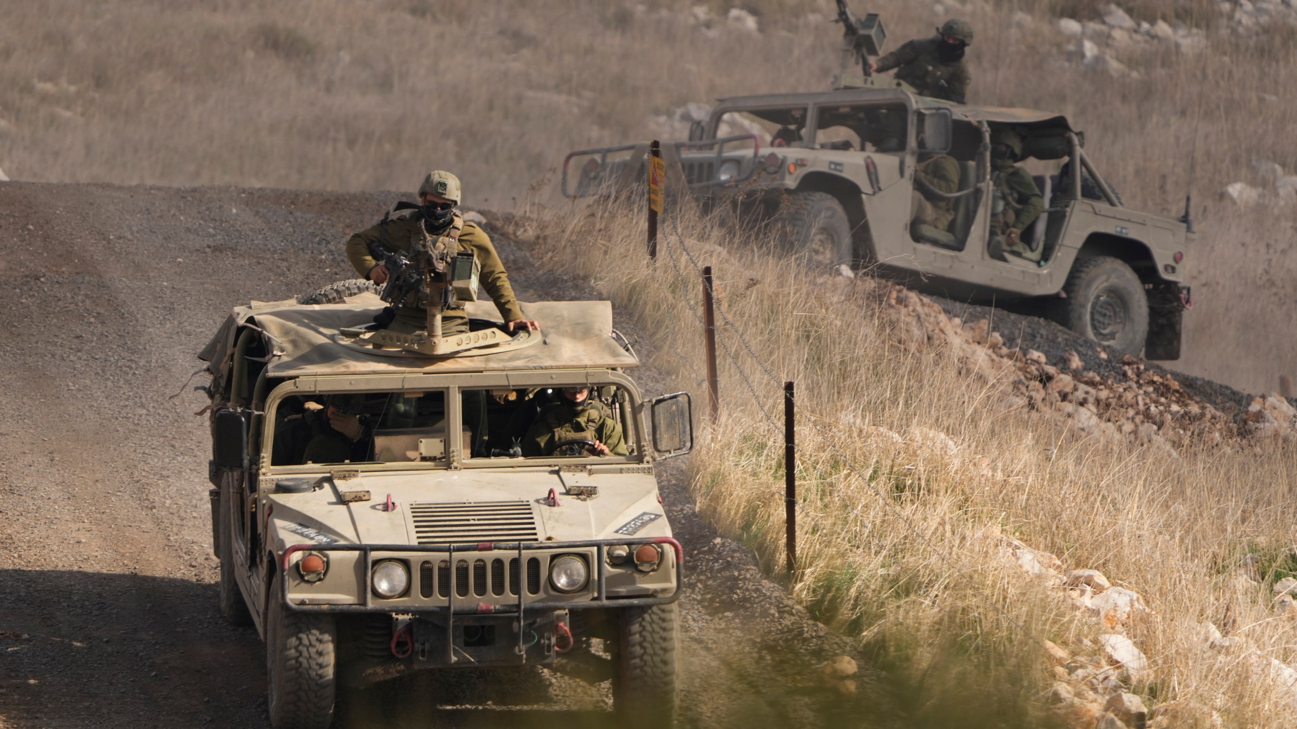 Israeli soldiers stand on armoured vehicles inside the buffer zone near the so-called Alpha Line that separates the Israeli-controlled Golan Heights from Syria, viewed from the town of Majdal Shams, Saturday, Dec. 21, 2024. (AP Photo/Matias Delacroix)