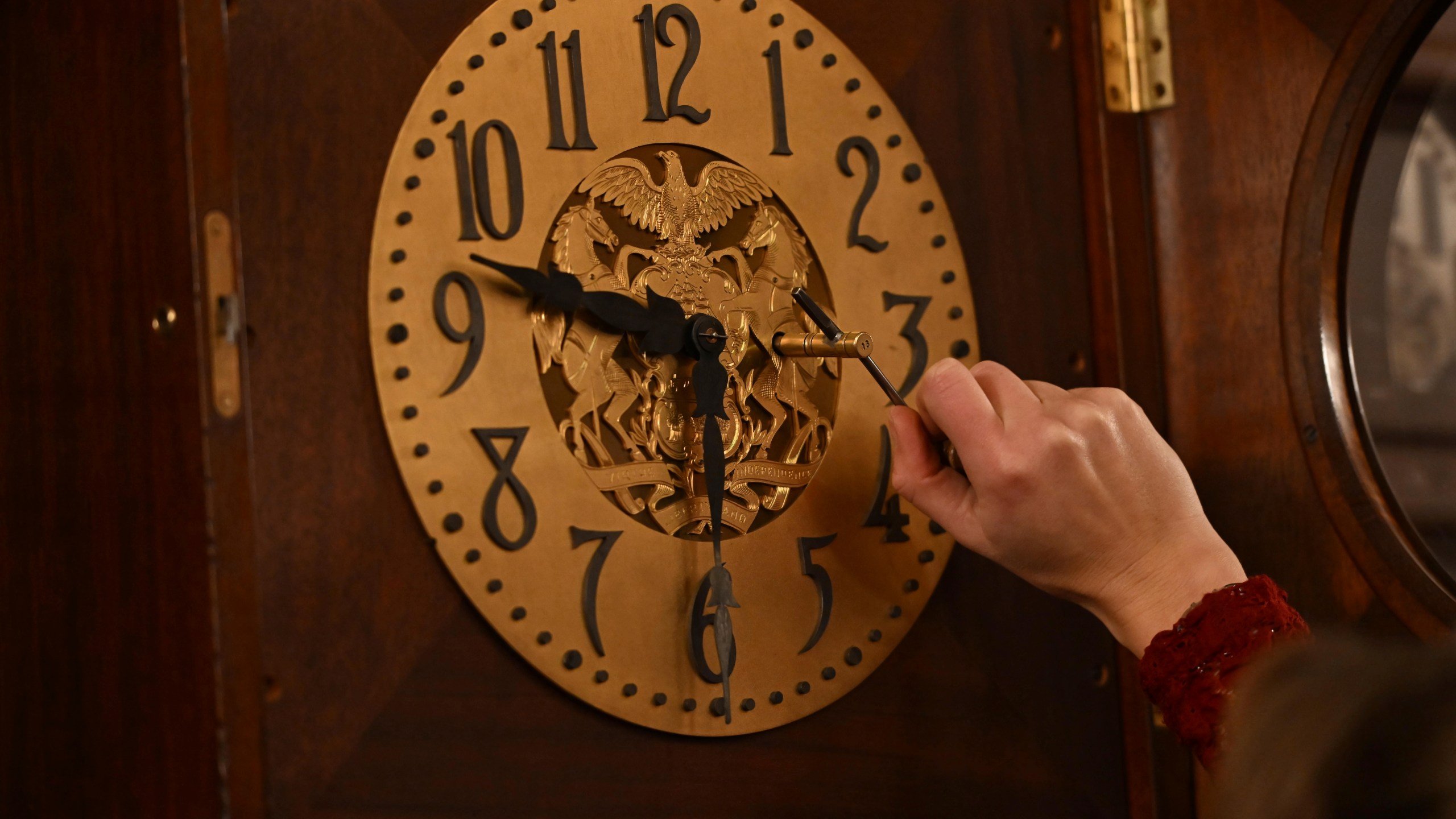 Bethany Gill winds a clock in the Pennsylvania Supreme Court chamber, Dec. 13, 2024, in Harrisburg, Pa. It's one of 273 clocks in Pennsylvania's ornate state Capitol complex buildings that must be wound by hand. (AP Photo/Marc Levy)