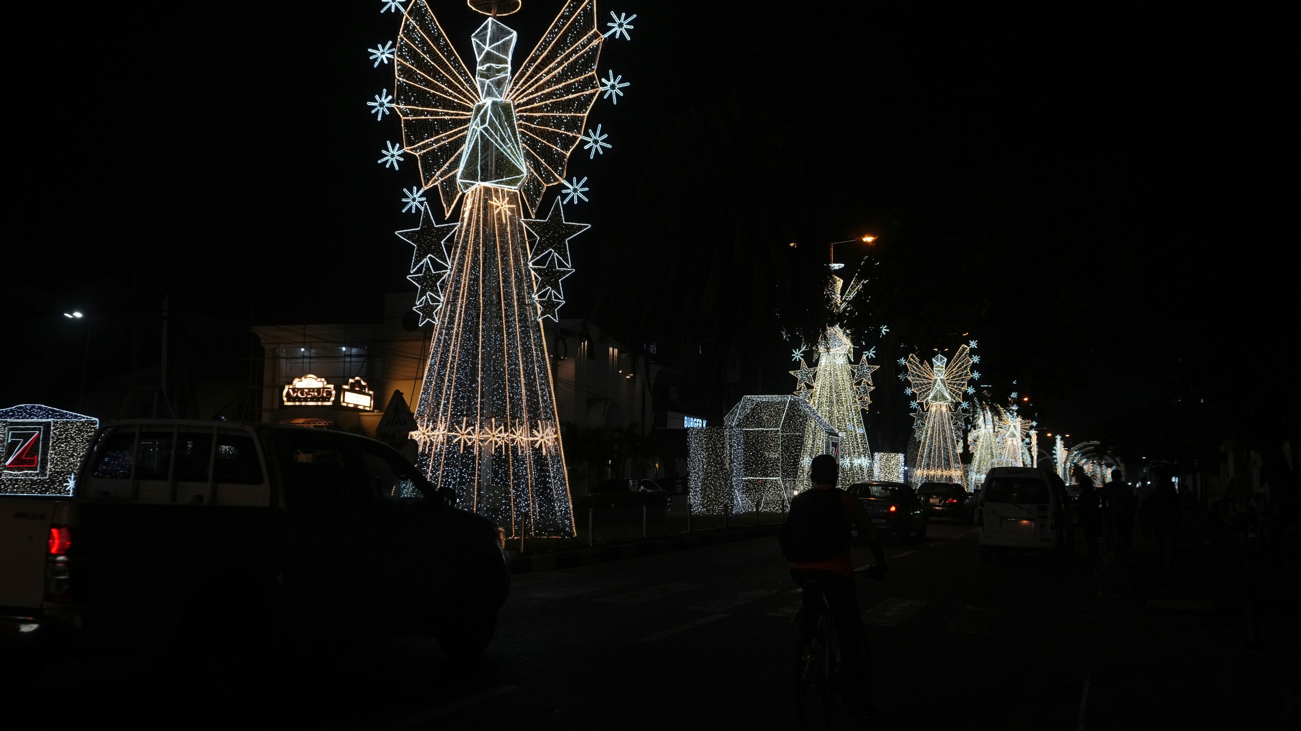 Cars drive past Christmas decorations on a street in Lagos, Nigeria, Friday, Dec. 20, 2024. (AP Photo/Sunday Alamba)