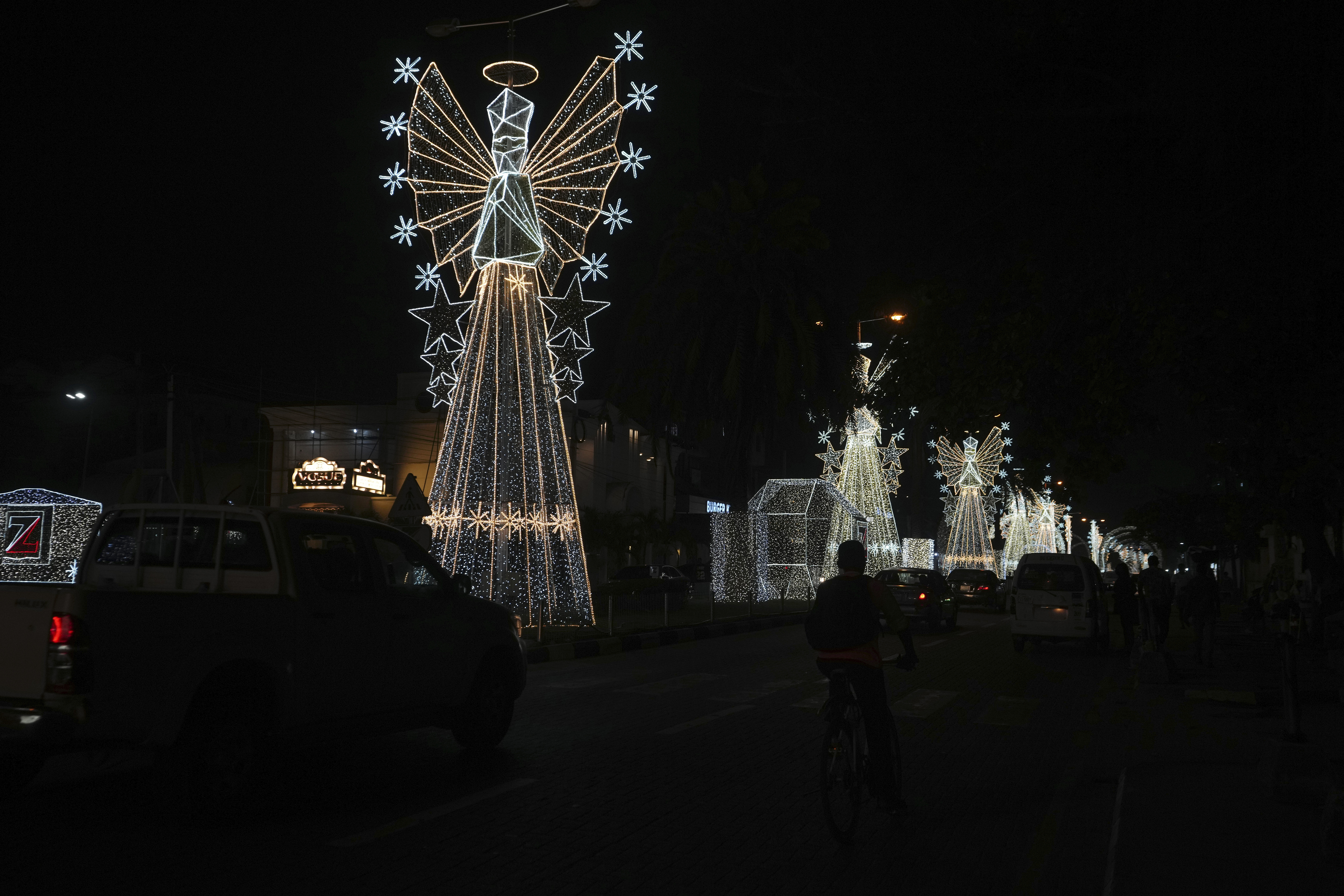 Cars drive past Christmas decorations on a street in Lagos, Nigeria, Friday, Dec. 20, 2024. (AP Photo/Sunday Alamba)