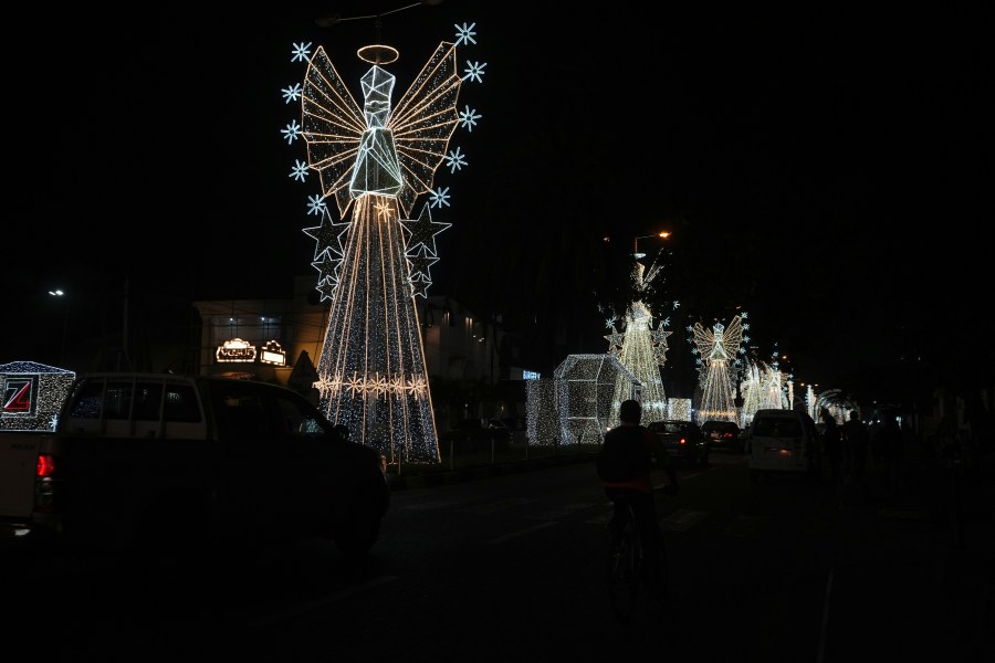 Cars drive past Christmas decorations on a street in Lagos, Nigeria, Friday, Dec. 20, 2024. (AP Photo/Sunday Alamba)