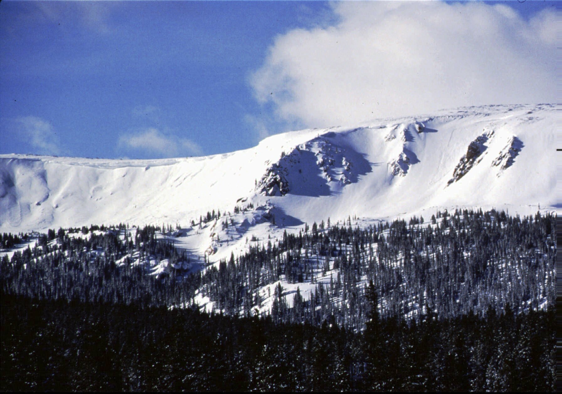 FILE - The sun shines onto Vasquez Cirque, new terrain for Winter Park Resort, Feb. 1997, Winter Park, Colo. (AP Photo/Byron Hetzler, File)