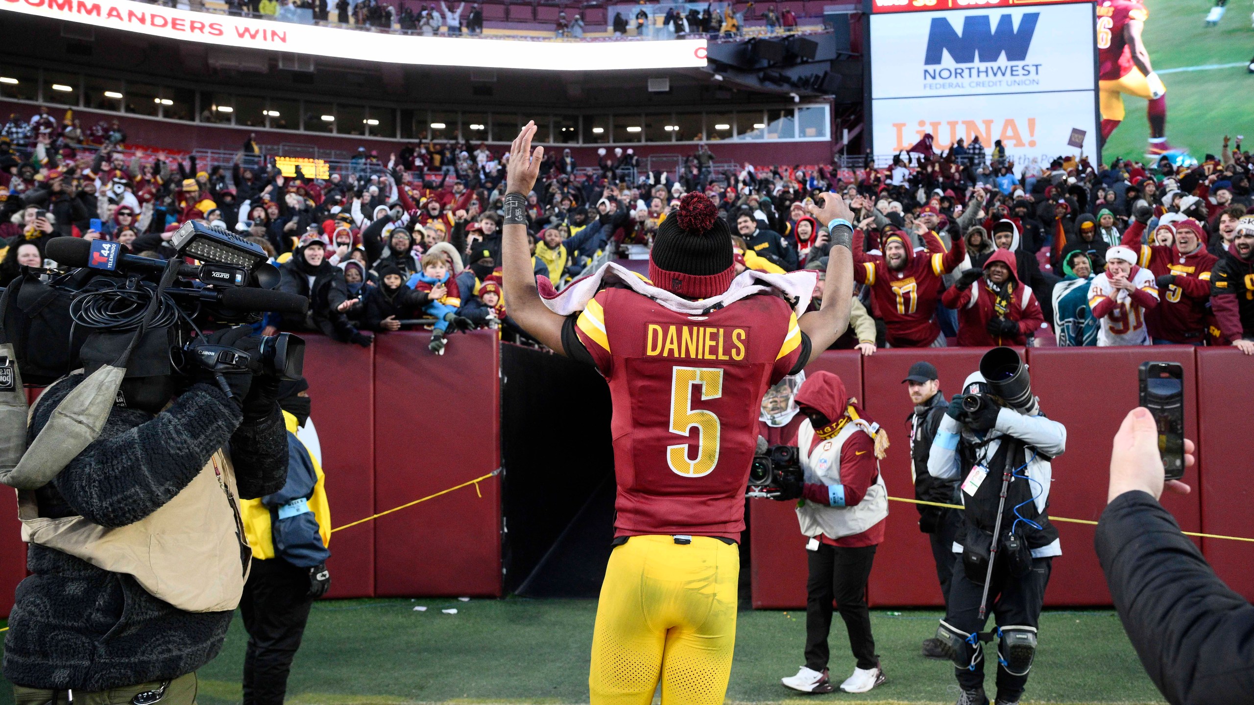 Washington Commanders quarterback Jayden Daniels (5) acknowledges fans as he heads off the field at the end of an NFL football game against the Philadelphia Eagles, Sunday, Dec. 22, 2024, in Landover, Md. (AP Photo/Nick Wass)